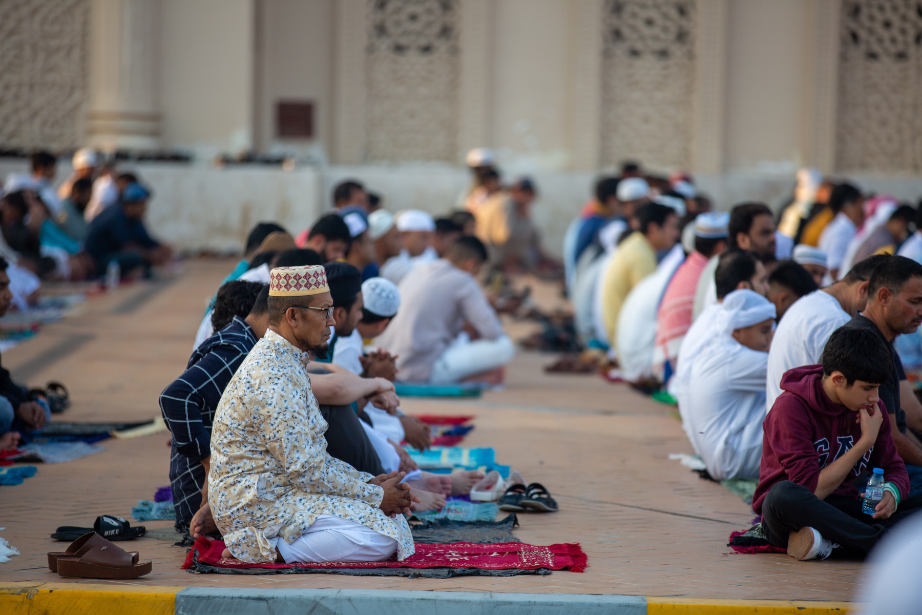 People kneel outside and pray as part of the Eid-al-Fitr celebration in the UAE