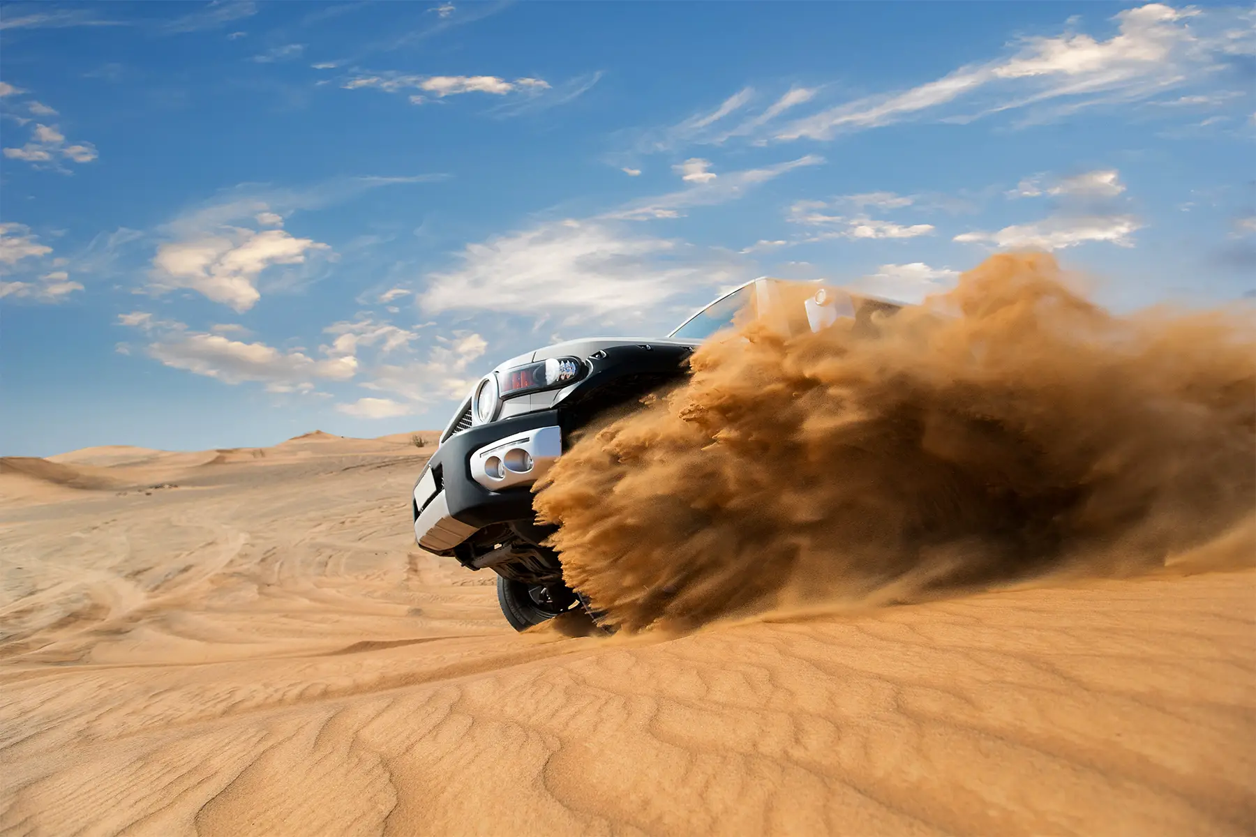 an SUV driving through the desert in the UAE