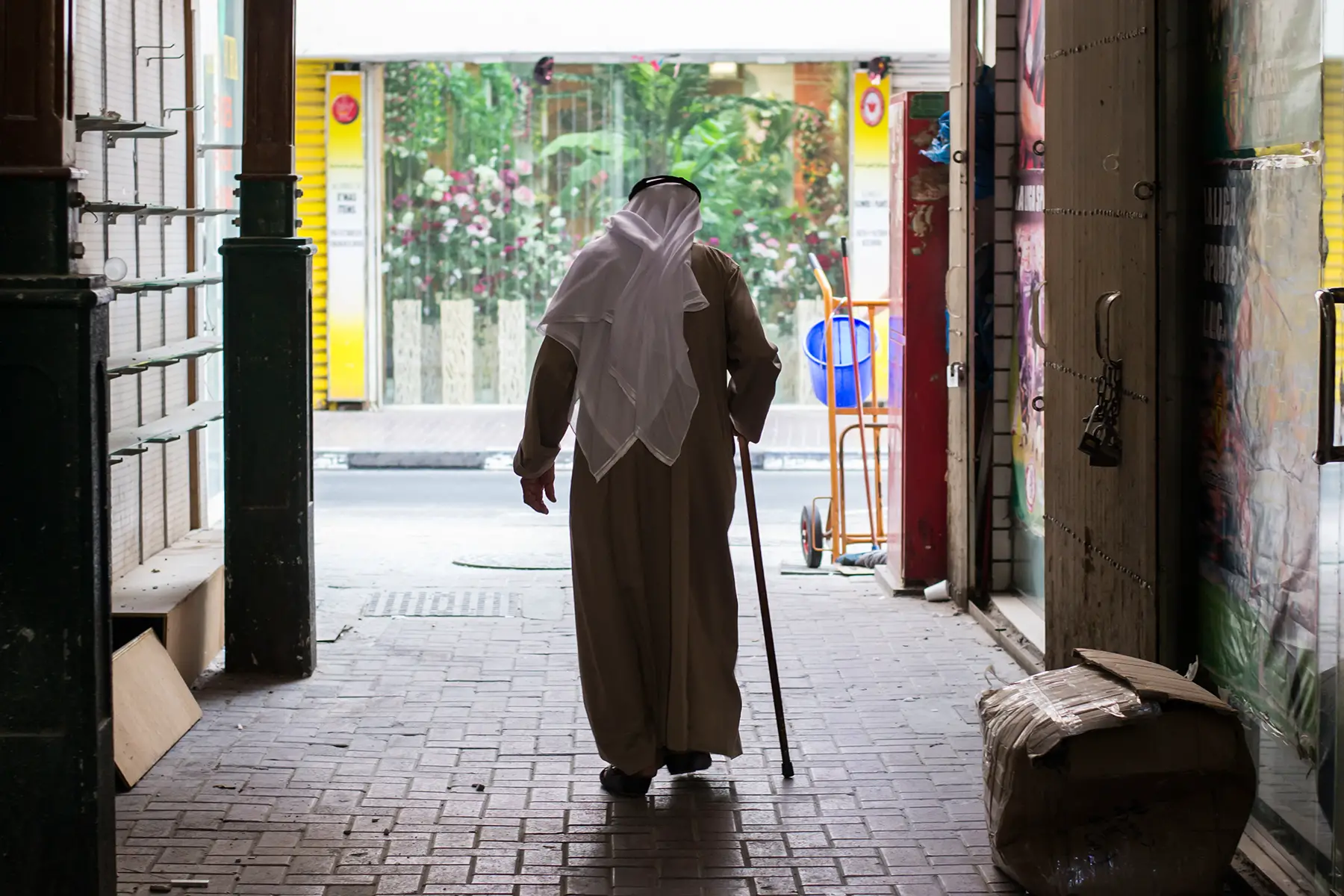 An elderly man walking through a souk in Dubai, UAE
