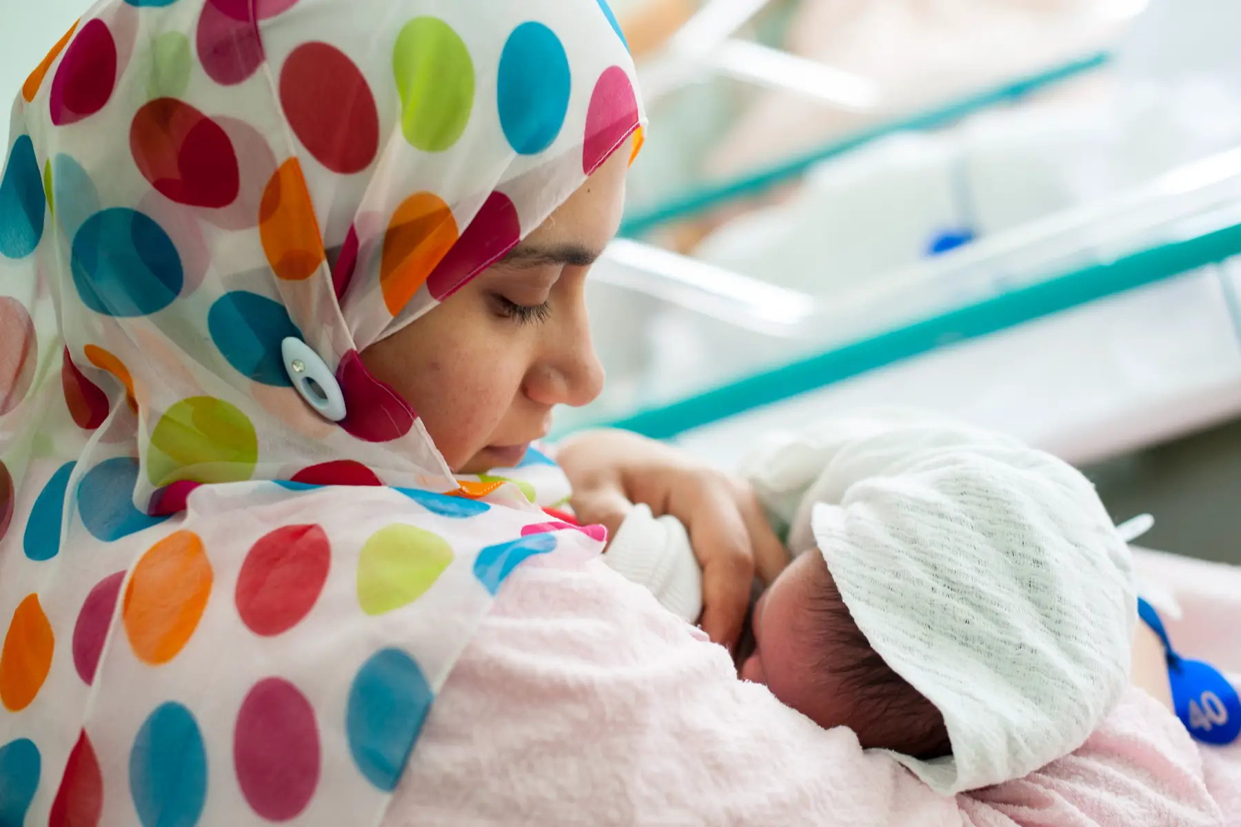 a muslim mum breastfeeding her newborn baby