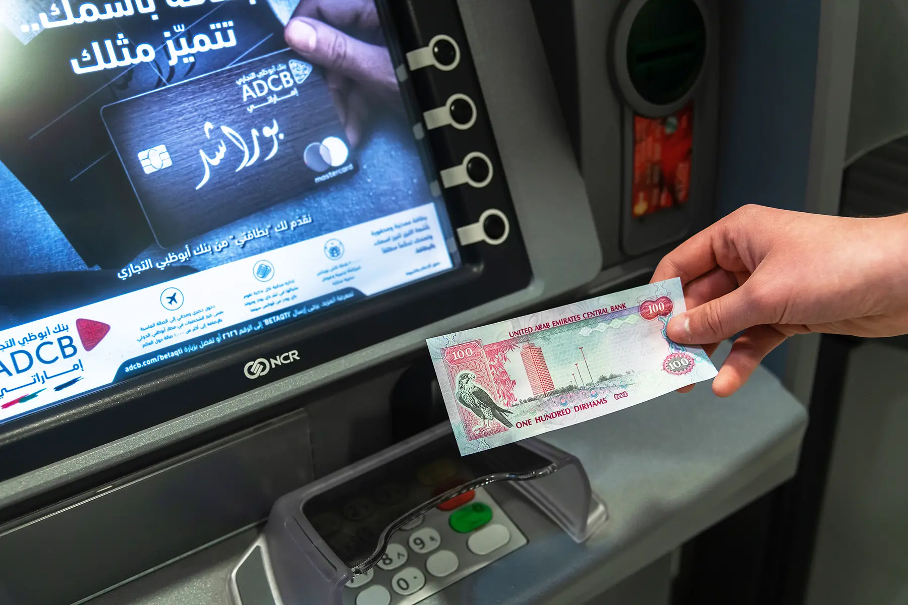 Withdrawing a UAE dirham note from an ATM