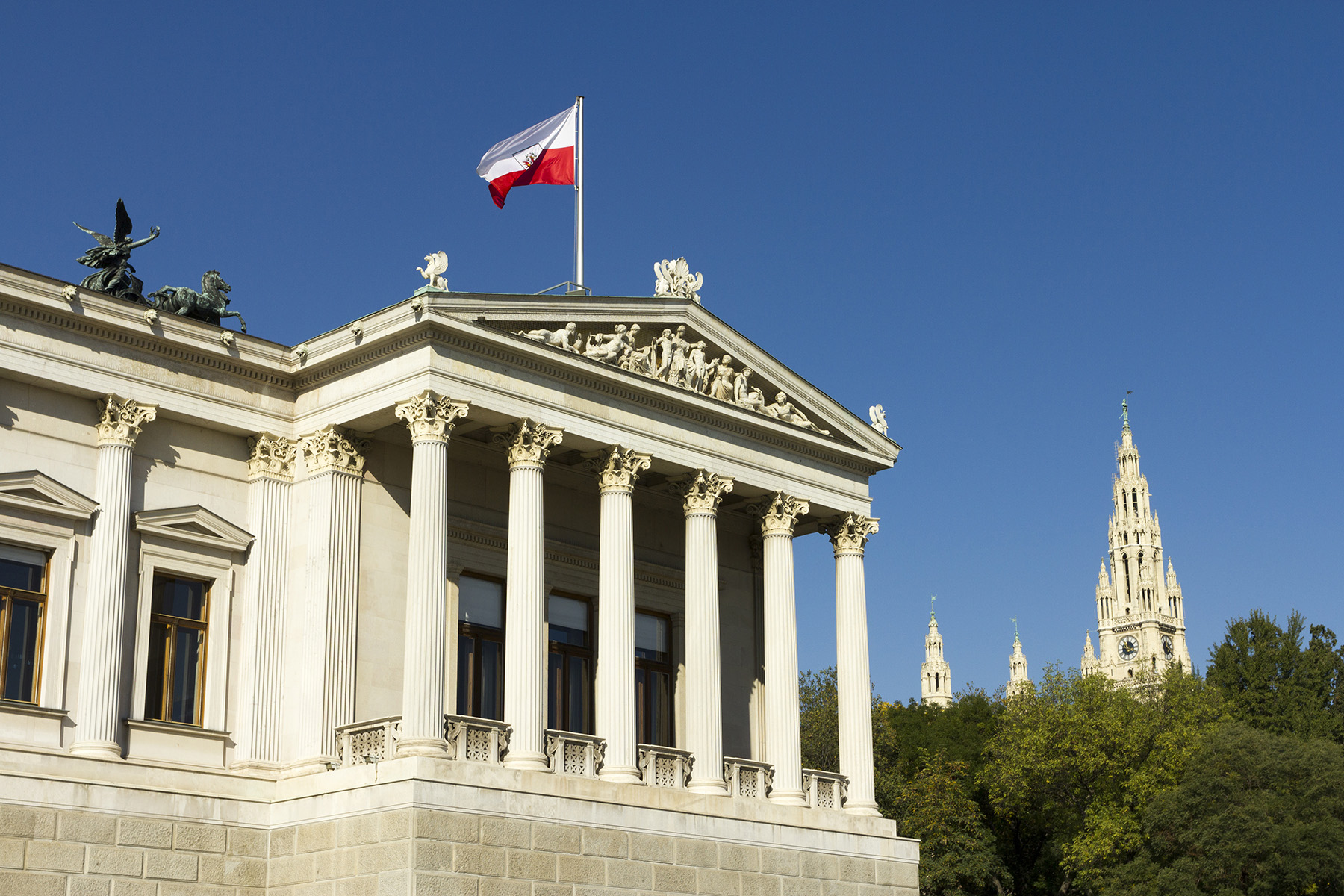 Exterior of the Austrian Parliament Building in Vienna, flag on top, day time