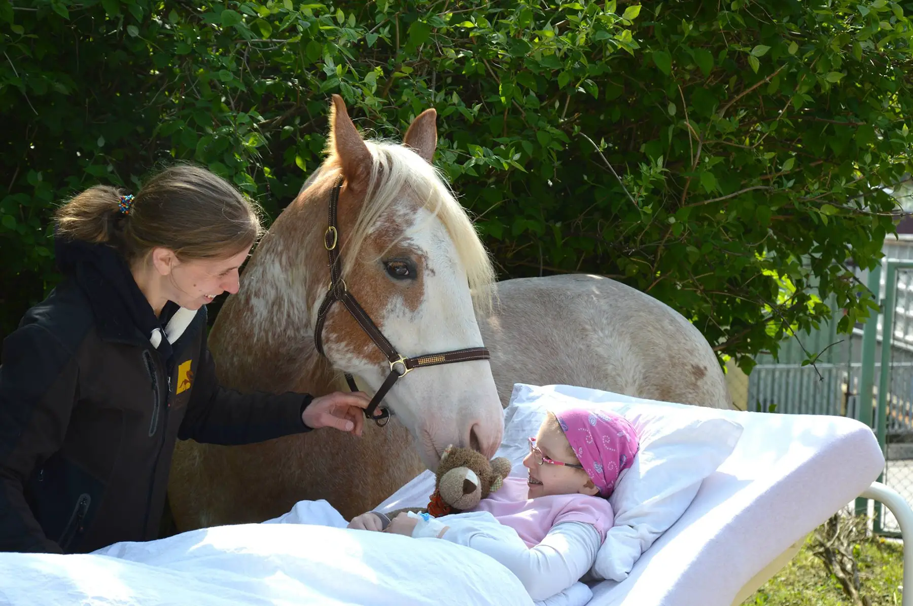 a young patient having a therapy session with a horse through the Lichtblickhof charity