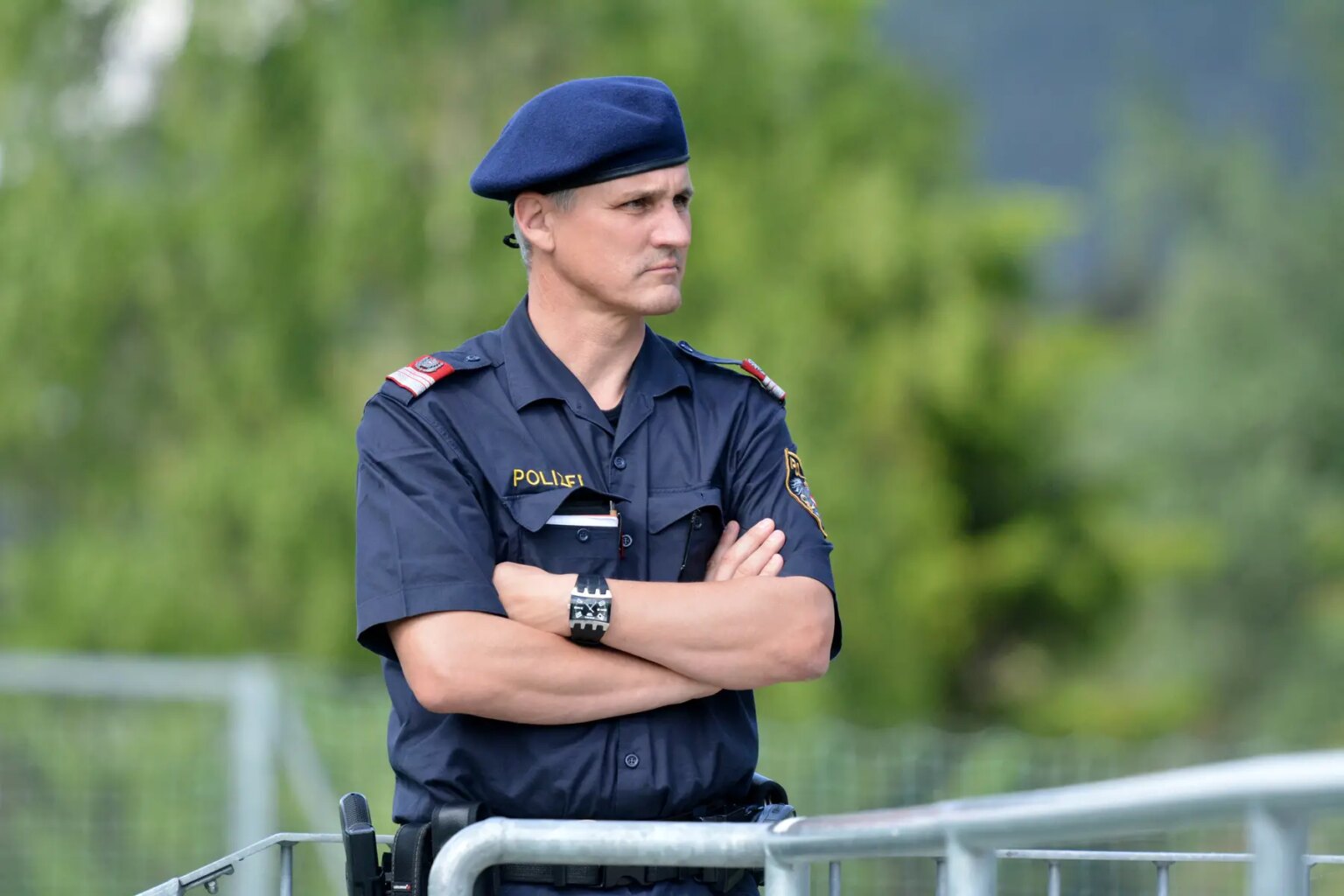 A police officer stands with his arms folded