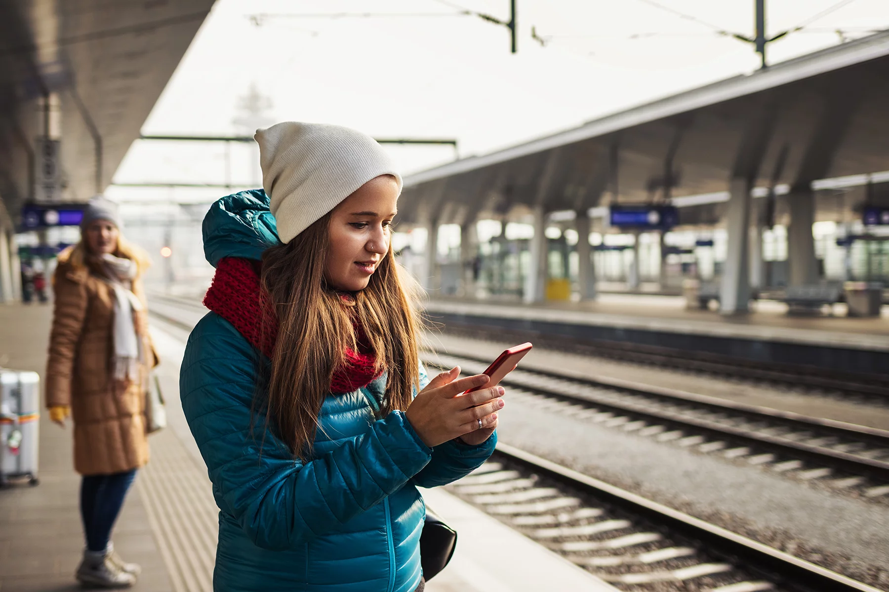 Woman using a language-learning app while waiting for a train in Vienna