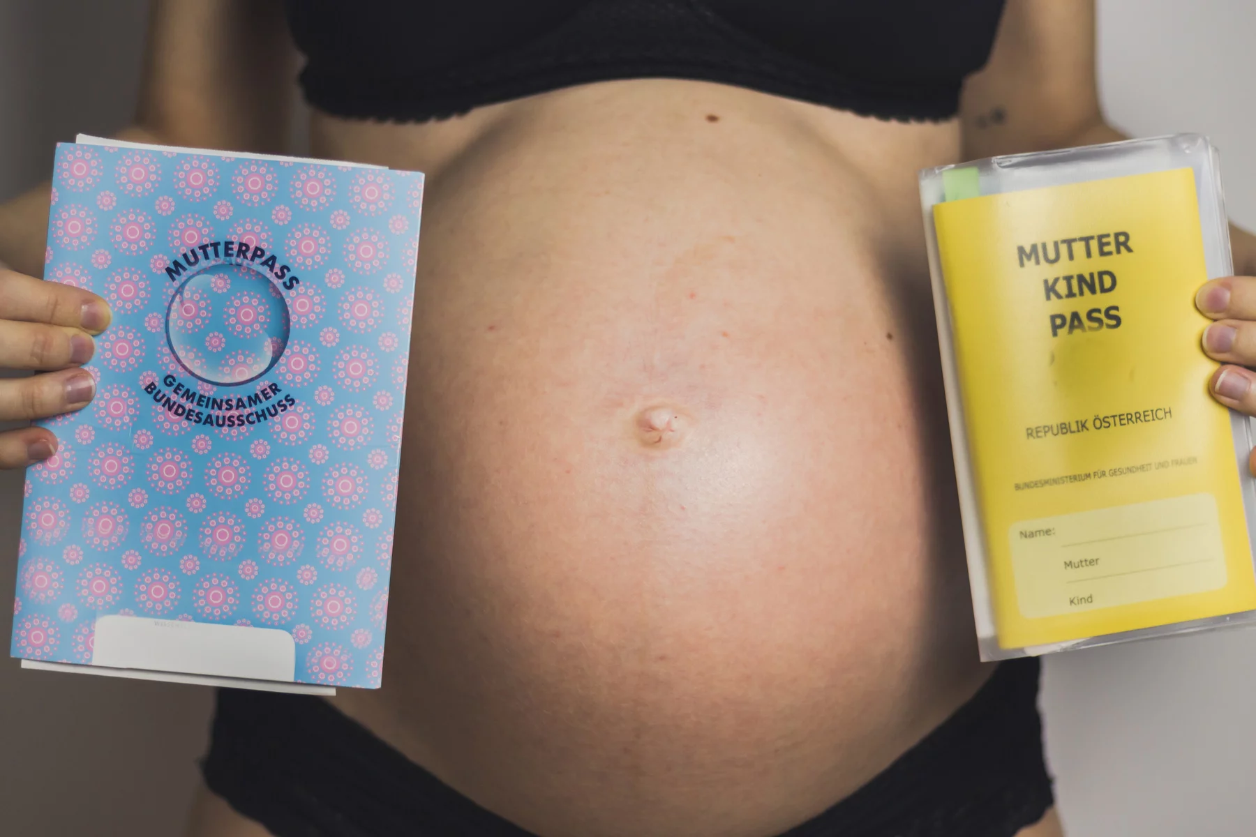 Pregnant woman holding Mutterpass
