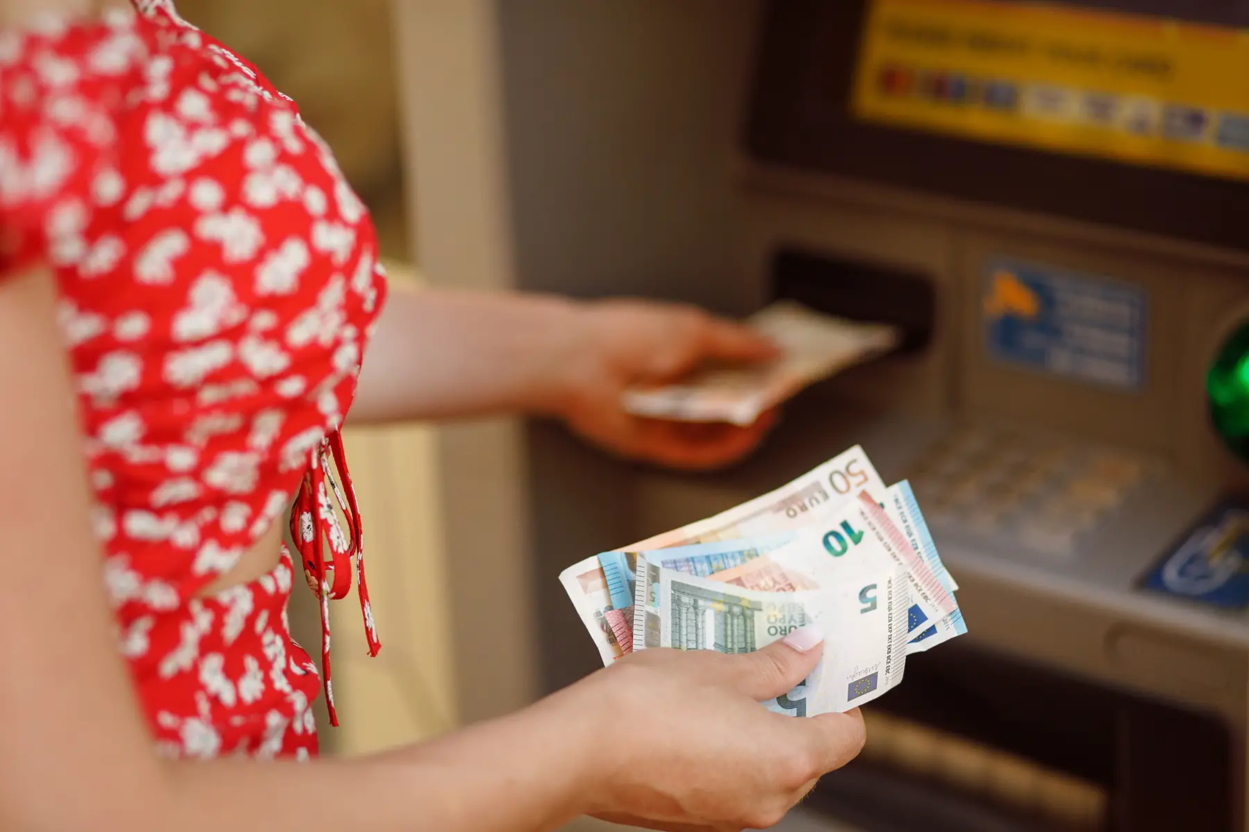 Woman withdrawing euros from an ATM
