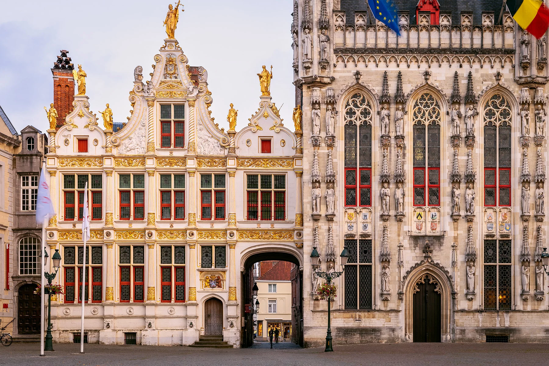 A gothic building with lots of gilded elements, EU and Belgian flags.
