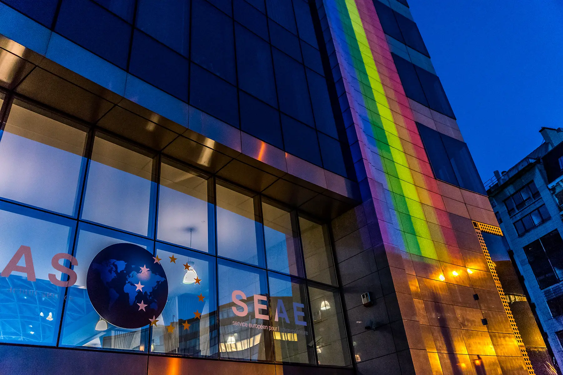 European Commission glass building lit up with rainbow colors