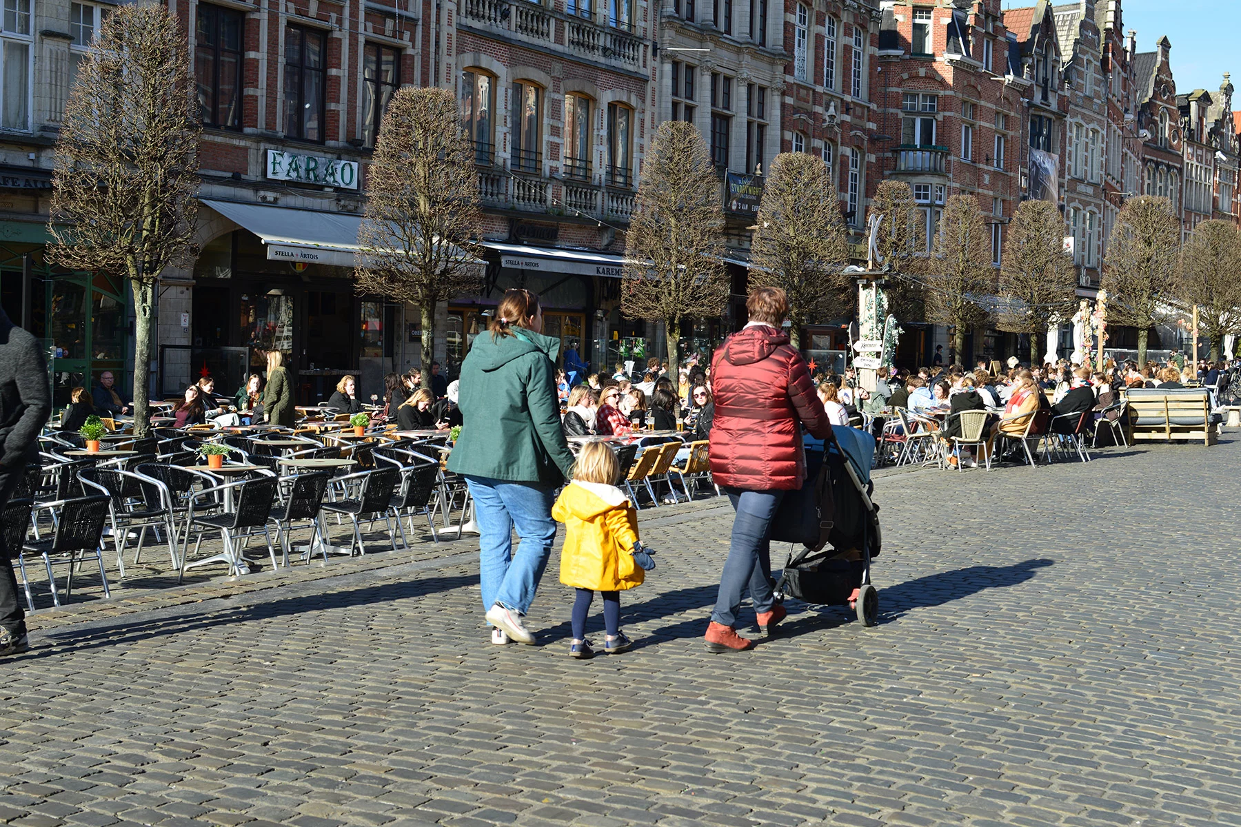 A family from behind, walking through a market square