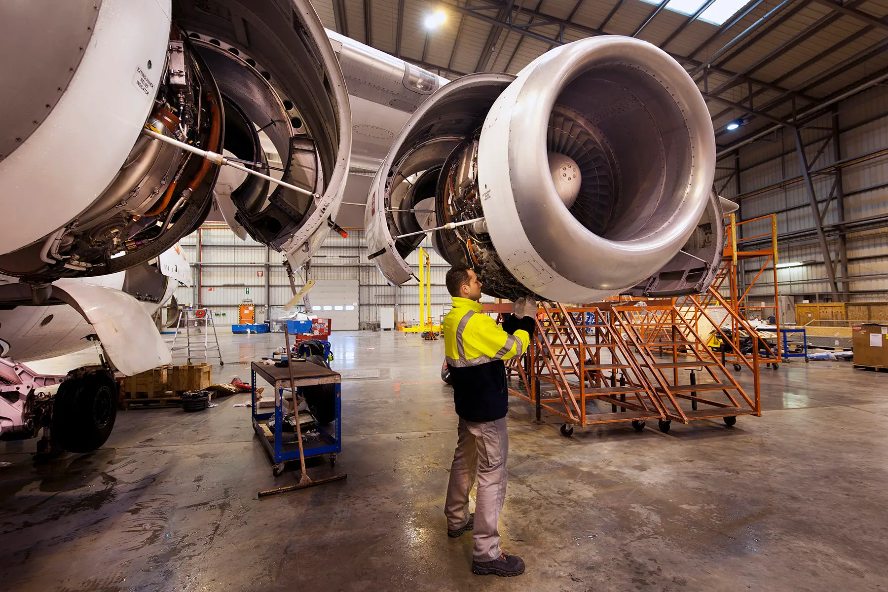 A maintenance worker inspecting an airplane engine