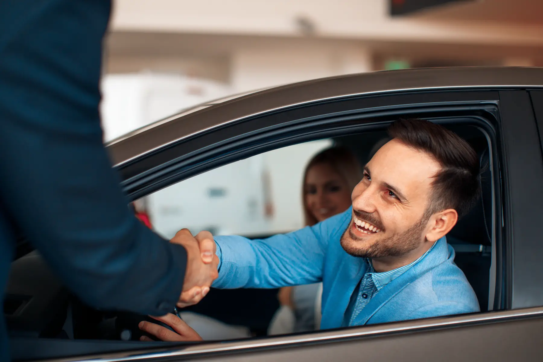 man shaking hands with car broker after buying a car
