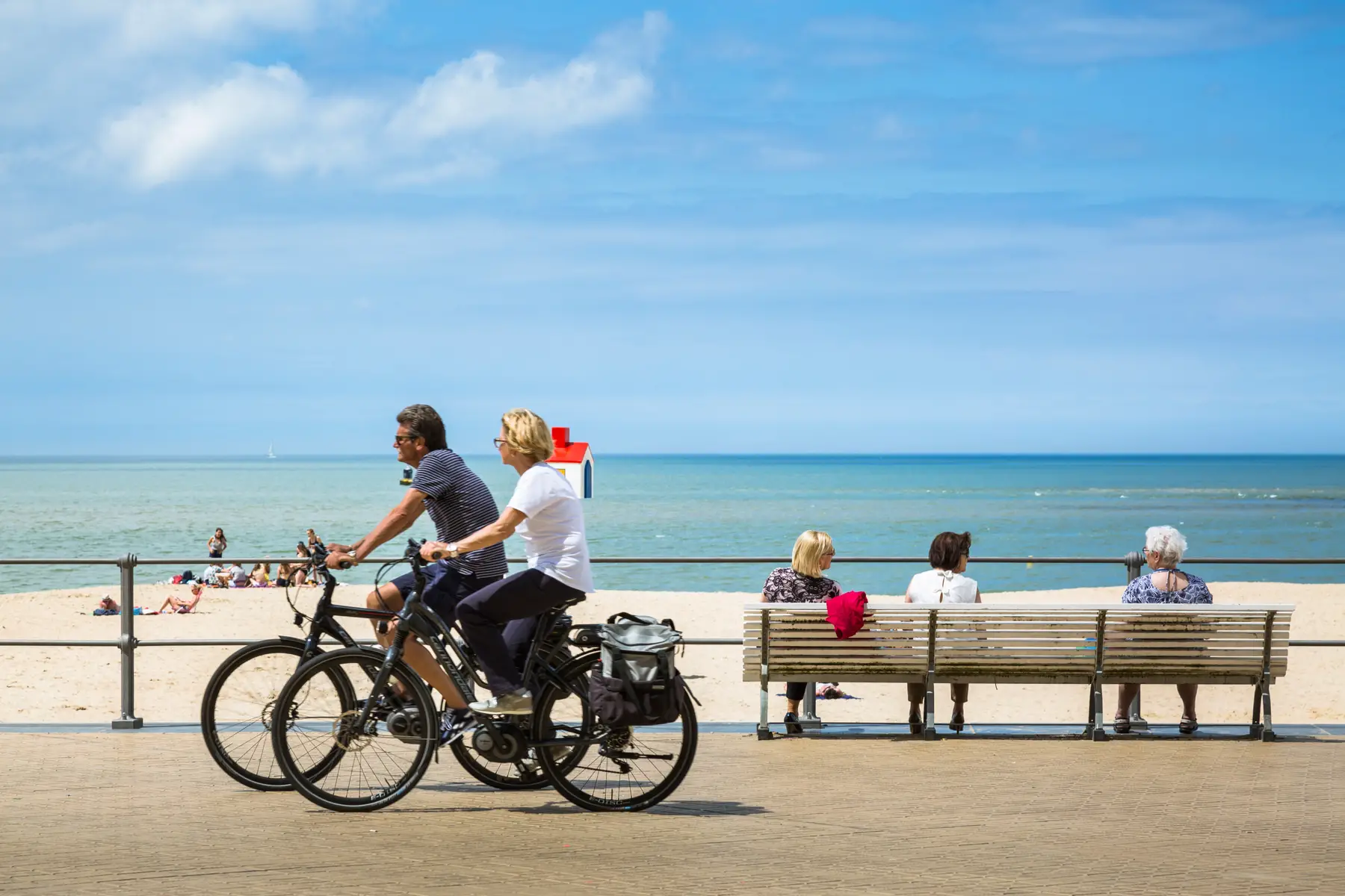 older couple cycling along a pier at the beach in ostend belgium