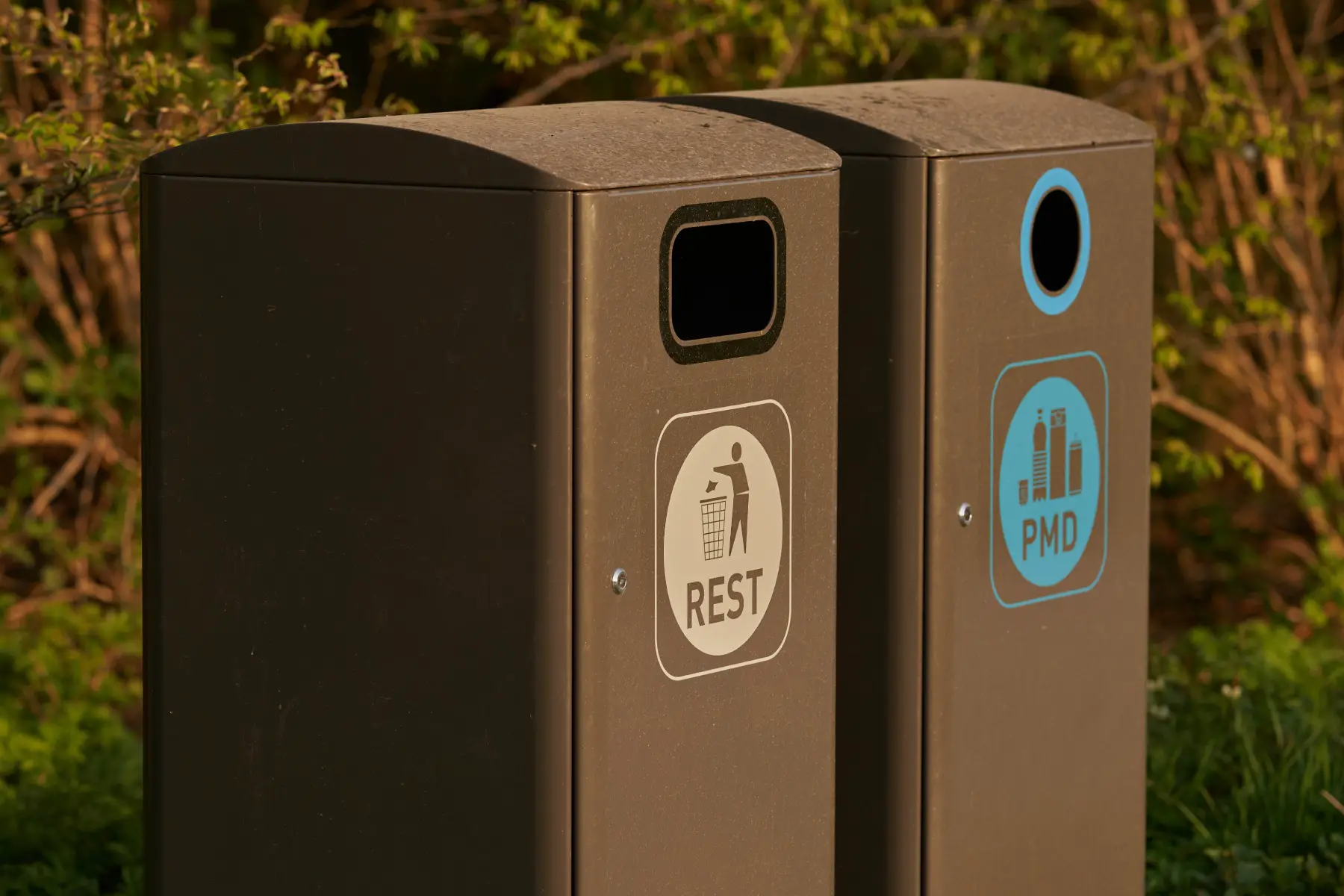 two trash containers in a Belgian nature reserve, one is for PMD (recycling plastic packaging, metal packaging and drink packaging) and the other is for general waste