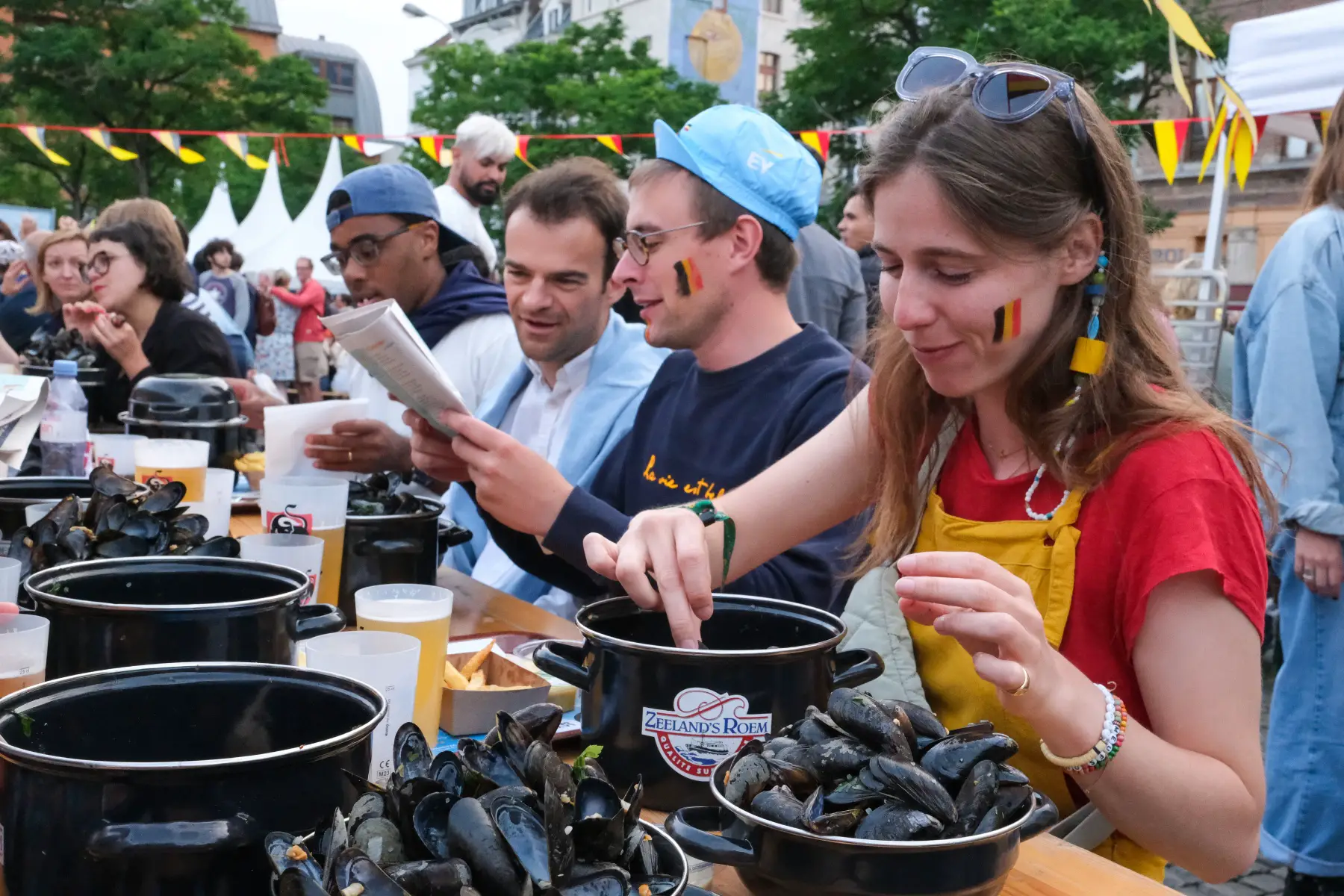 A crowd eat mussels ('moules frites’) and Belgian fries at the Resto National event in Brussels during Belgian National Day in 2023