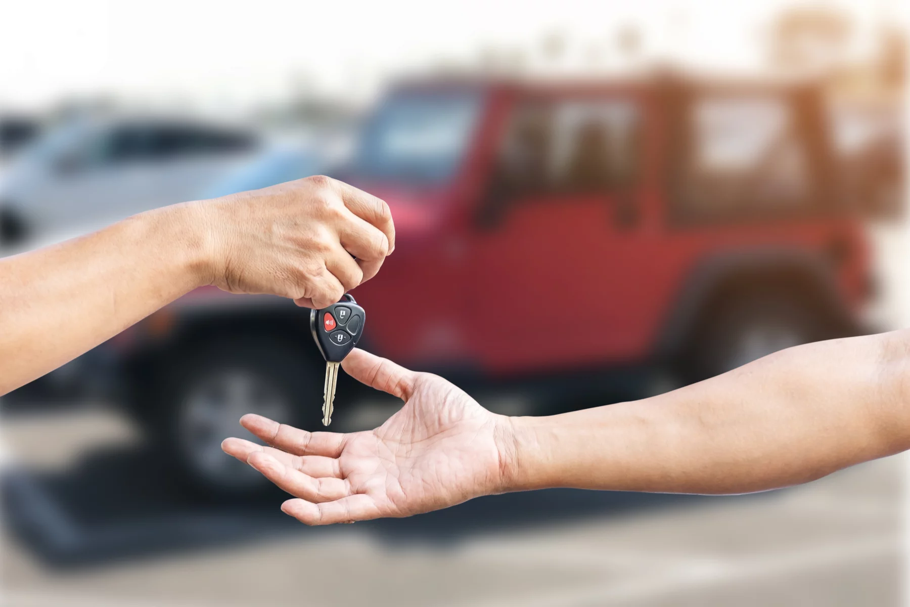 car seller handing car key to buyer