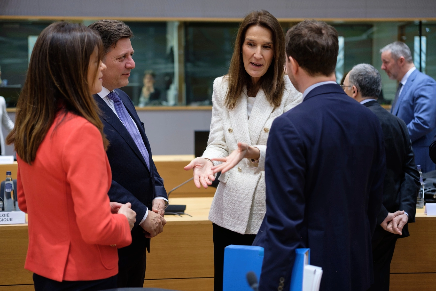 the former prime minister of Belgium, Sophie Wilmes, standing and chatting to three other politicians in the EU Council headquarter in March, 2022