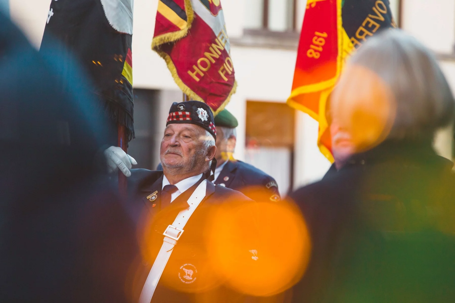 Old man in uniform holding a banner in Antwerp. He is part of the British 49th West-Riding Infantry Division Polar Bear Association.
