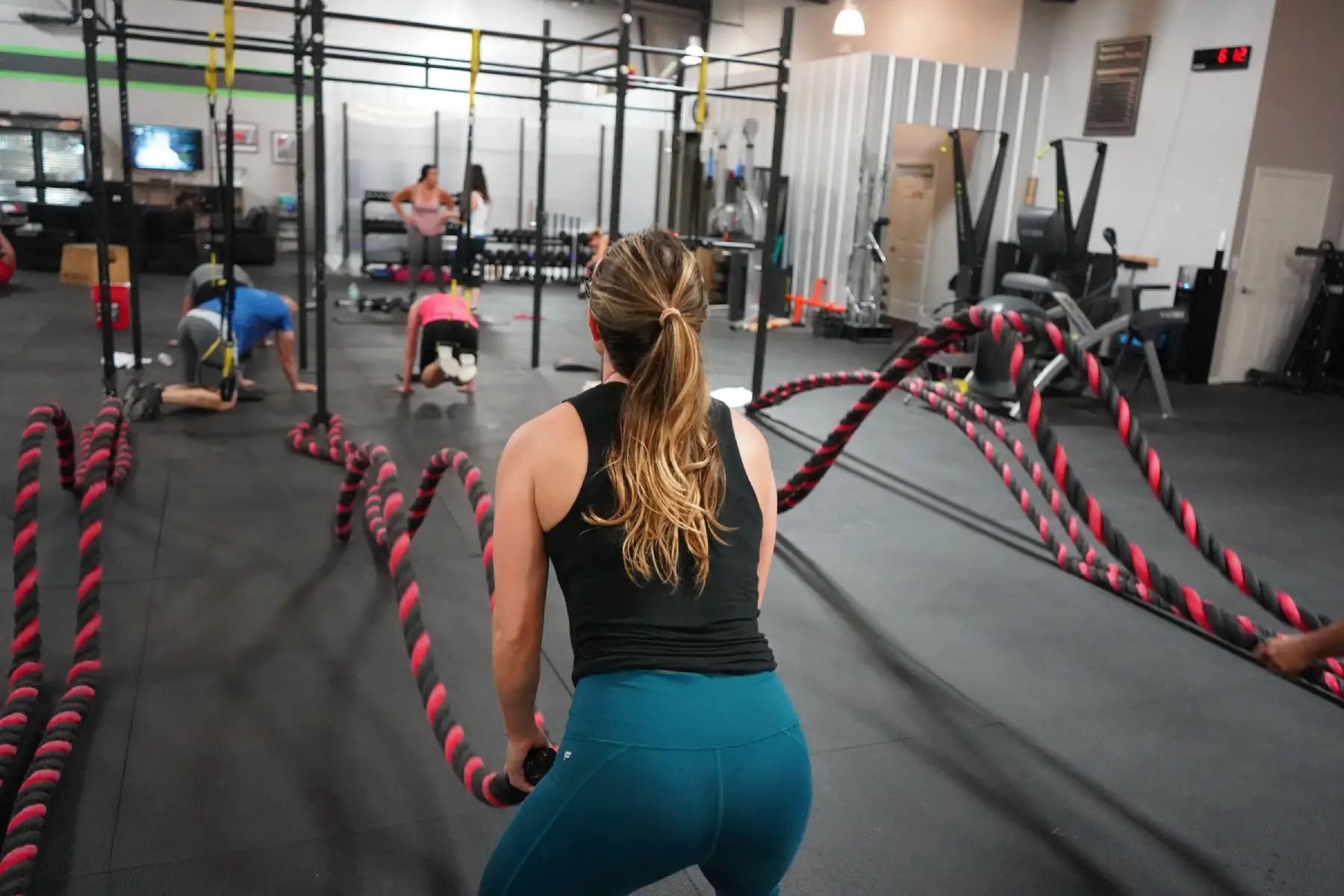 Woman exercising with battleropes in crossfit class