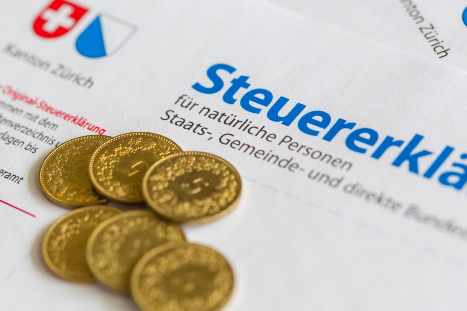 A few coins sit atop an Zurich income tax form