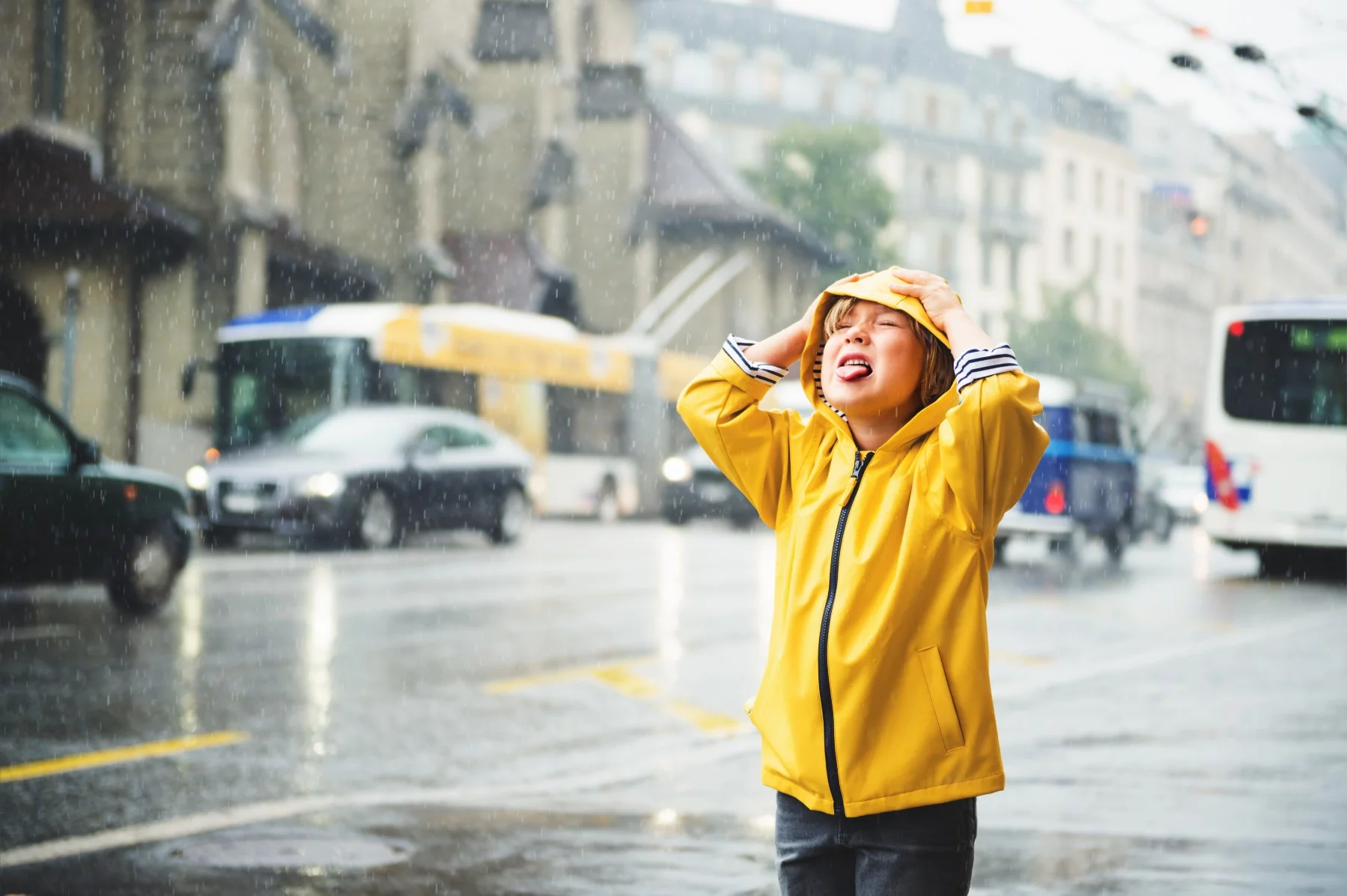 child stands in the rain with tongue out in Switzerland