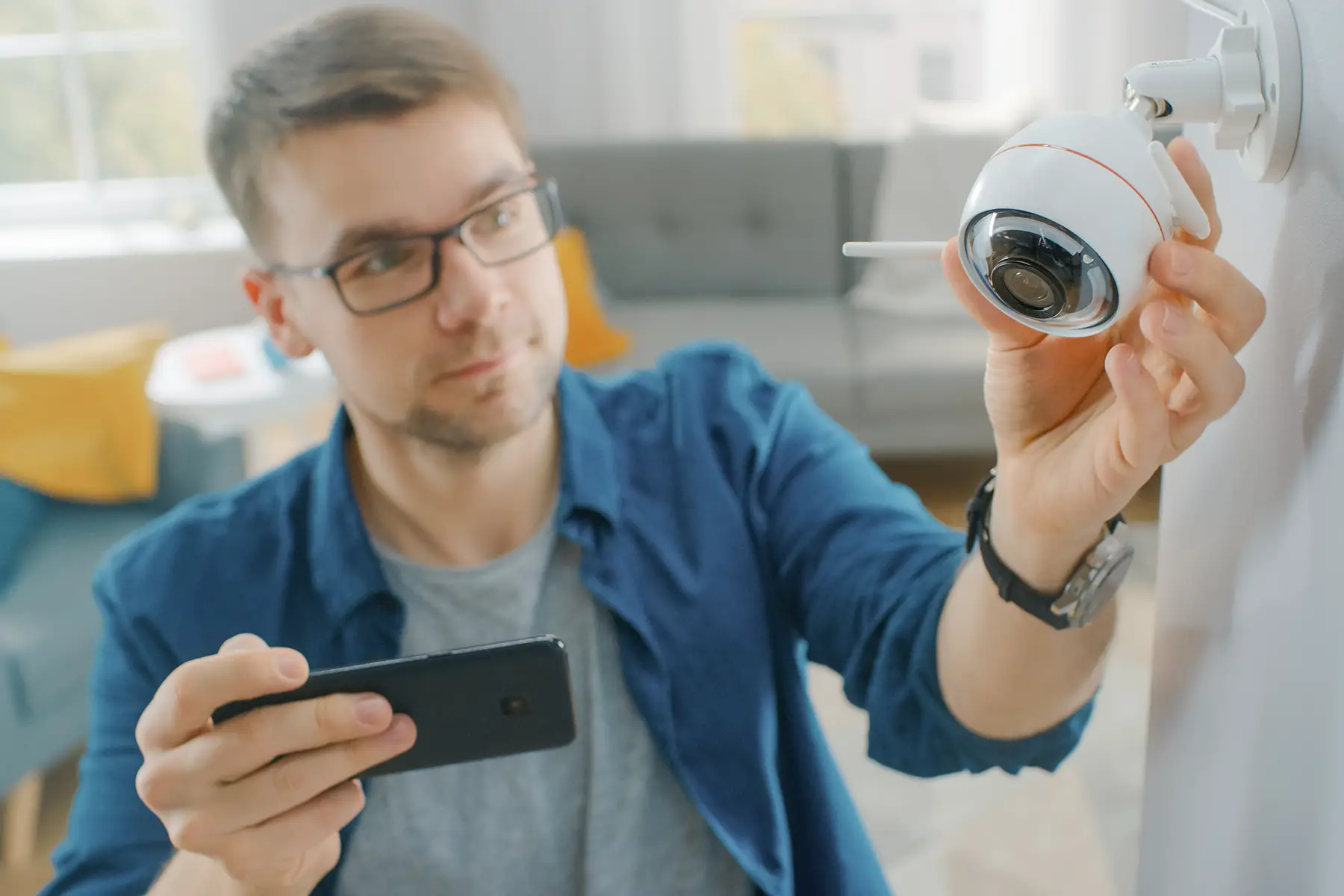 man fitting camera as part of his home security system