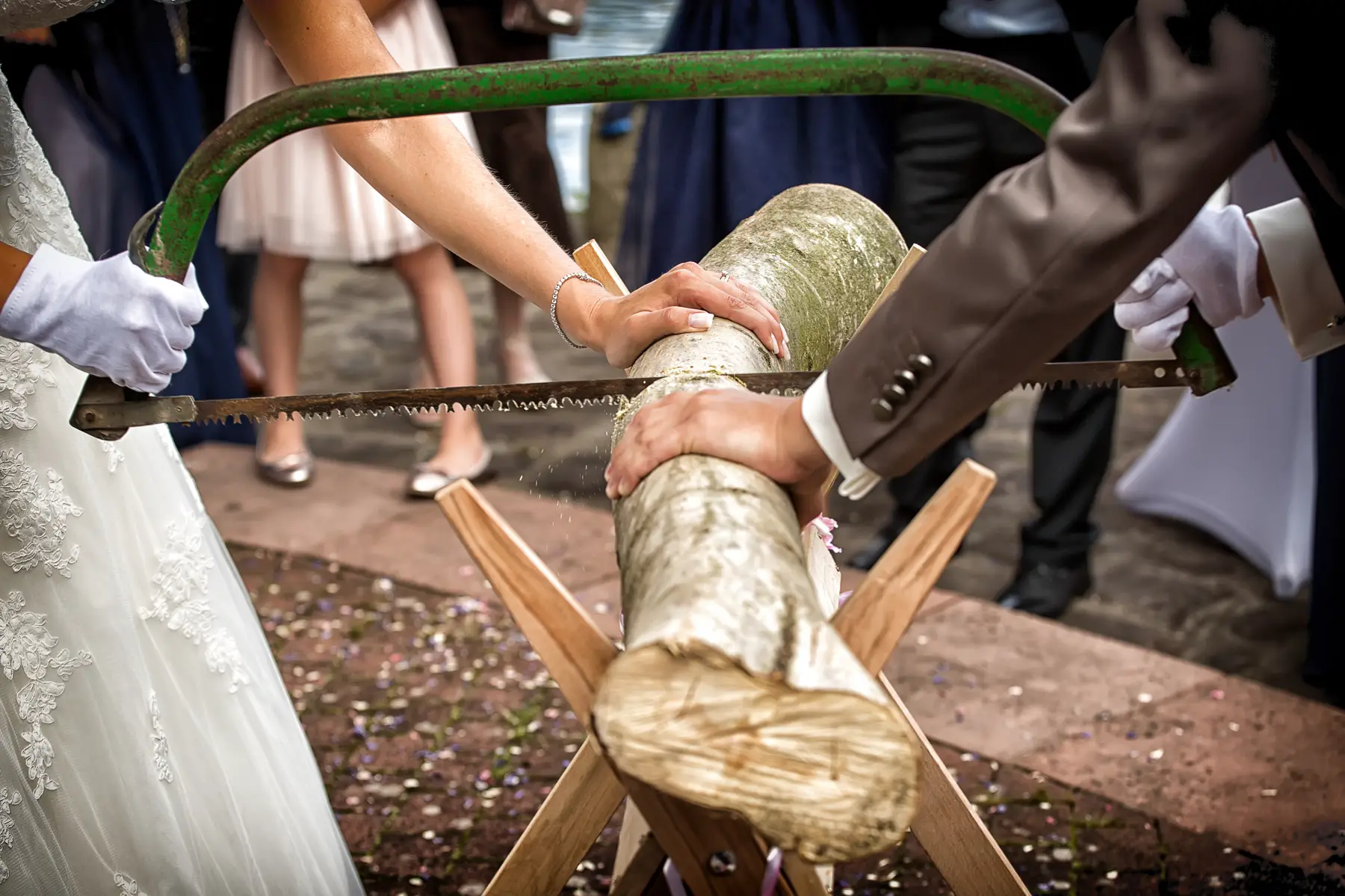Bride and groom sawing a log at their wedding