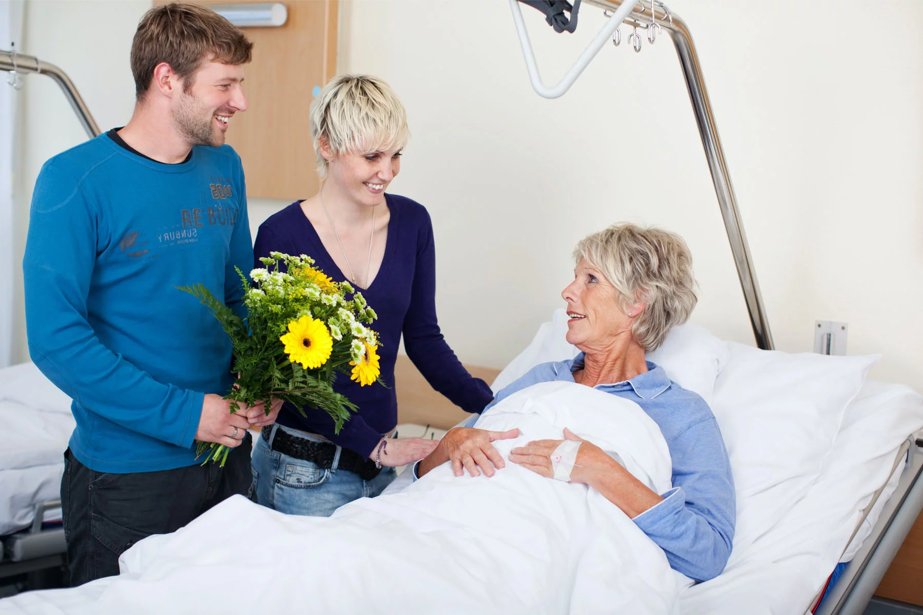 a young couple visiting an elderly family member in hospital