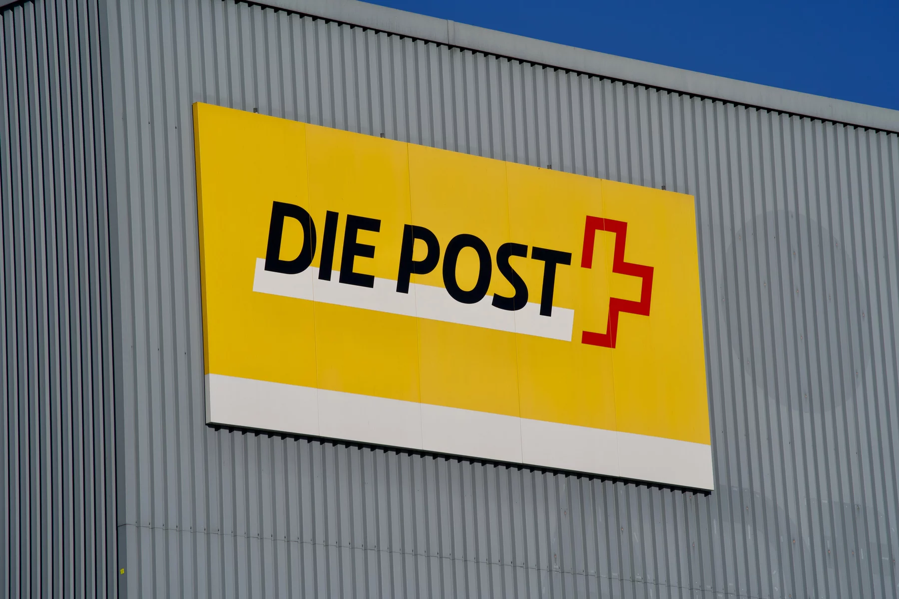 Swiss Post logo on the side of a building in German