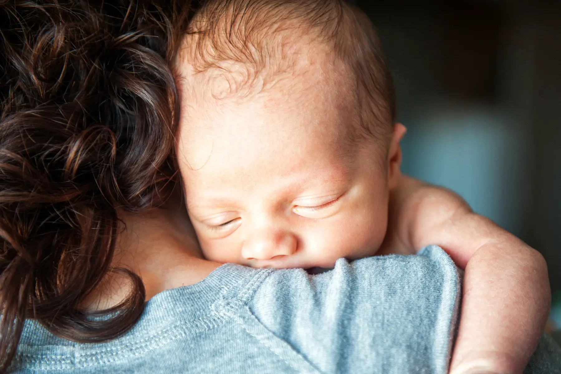 Tired newborn in her mother's arms