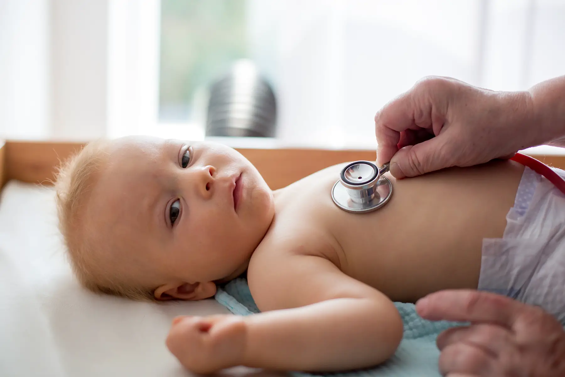 a baby having a well-child check-up with a doctor 