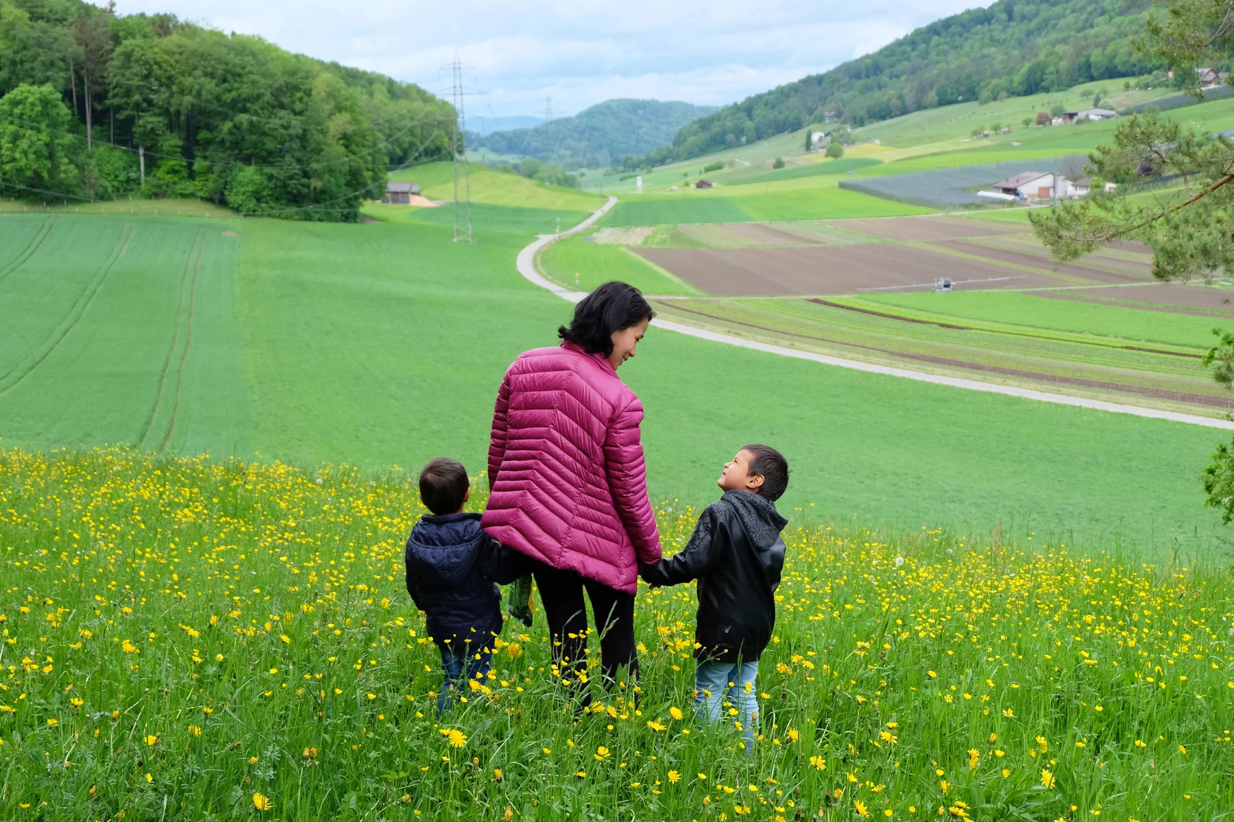 Woman walking in the Swiss countryside with her children