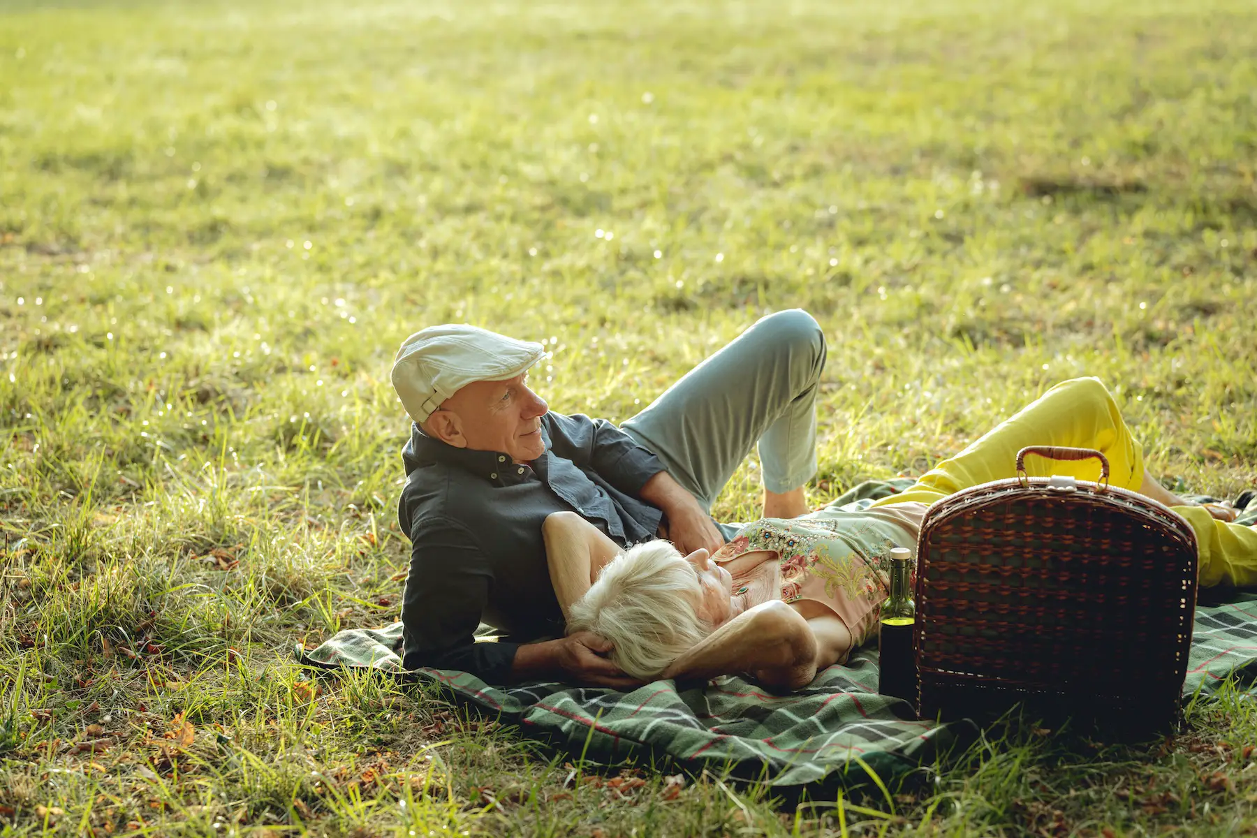 Senior couple relaxing on picnic blanket at the park