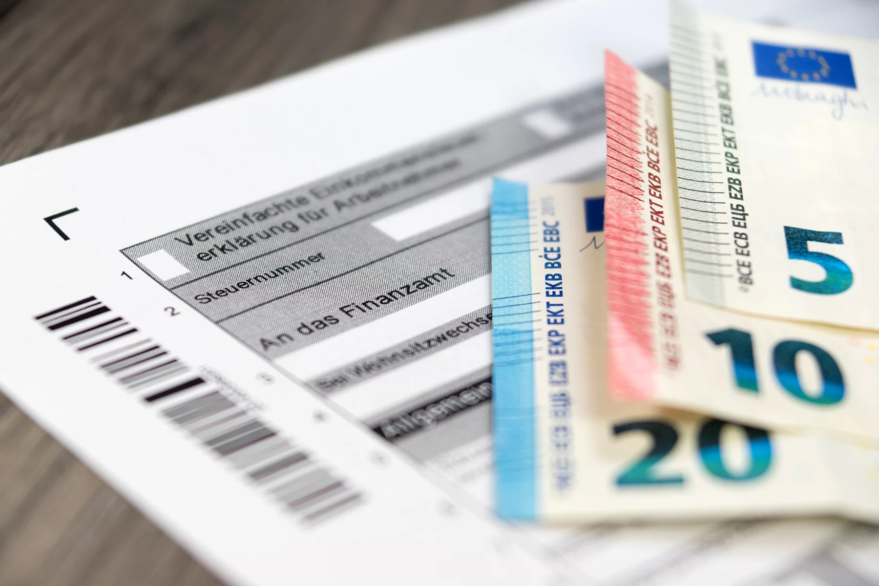 German income tax refund form with Euro notes laid on top