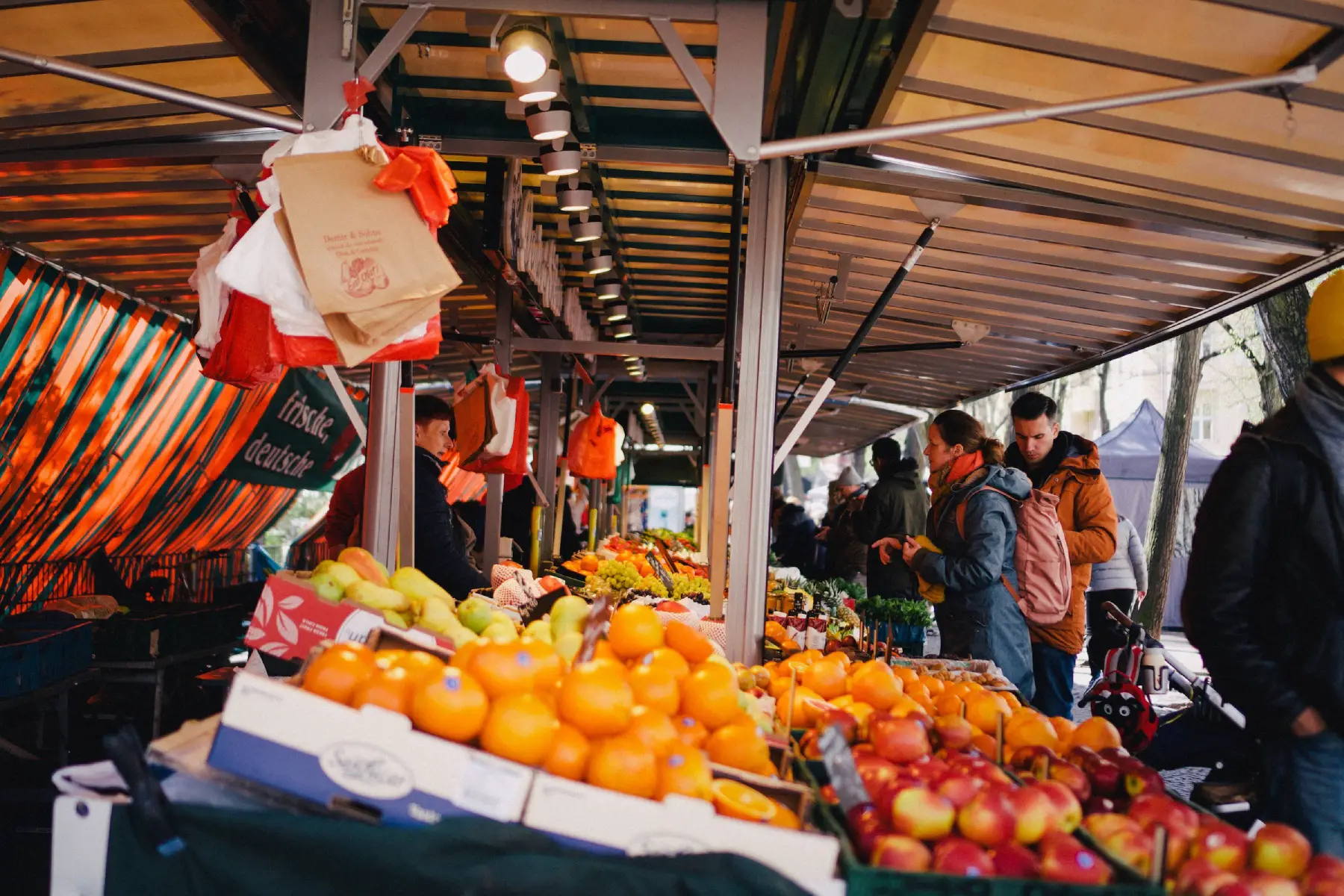Fruit vendor talking to customer at market