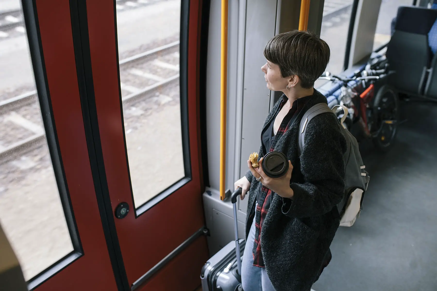 Woman waits at the exit of a train to continue on with her travels.