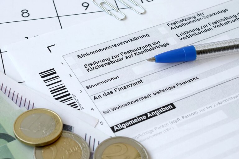Form for income tax in Germany. There's also some euro coins and a blue pen.