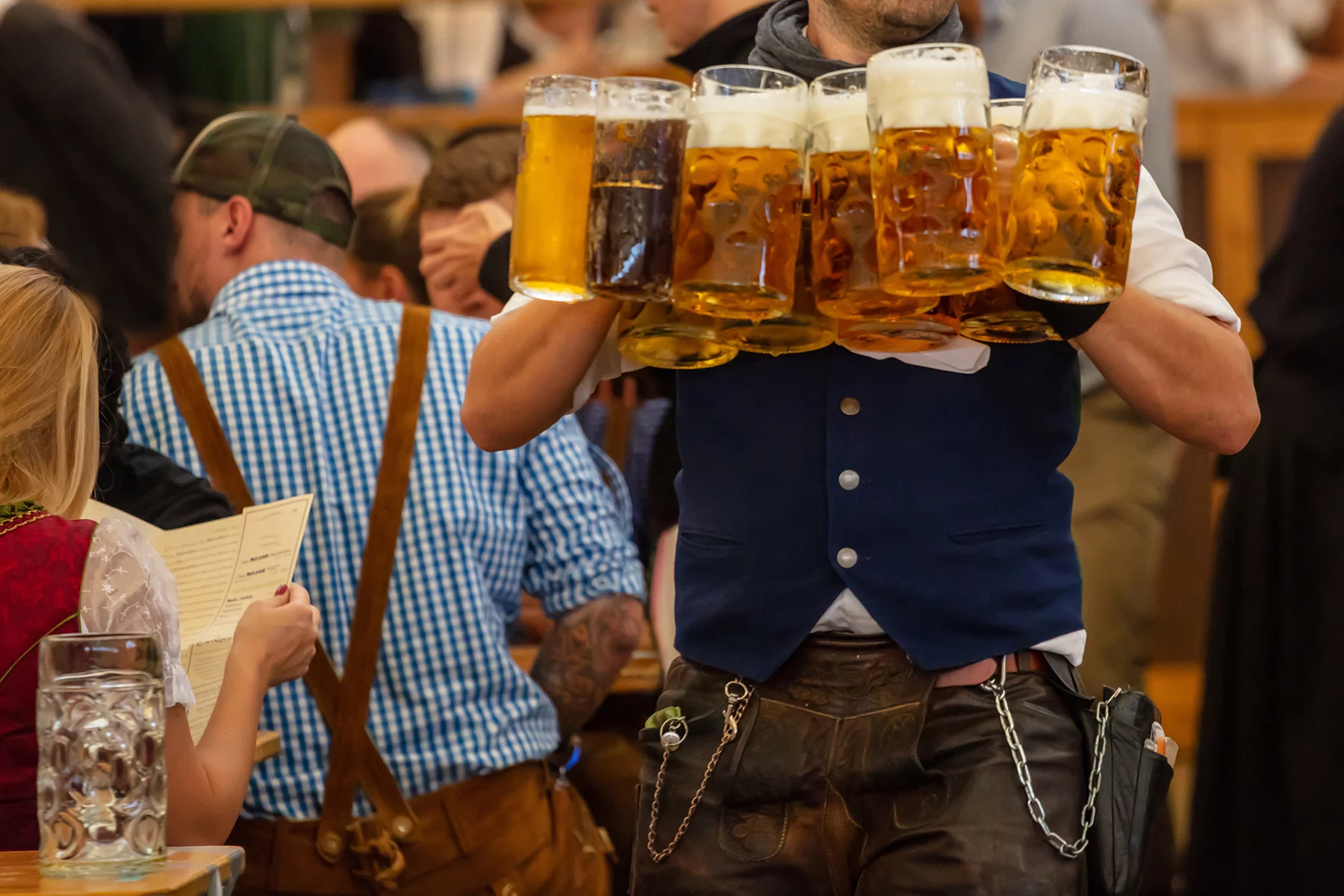 Man carrying a handful of beers at Oktoberfest