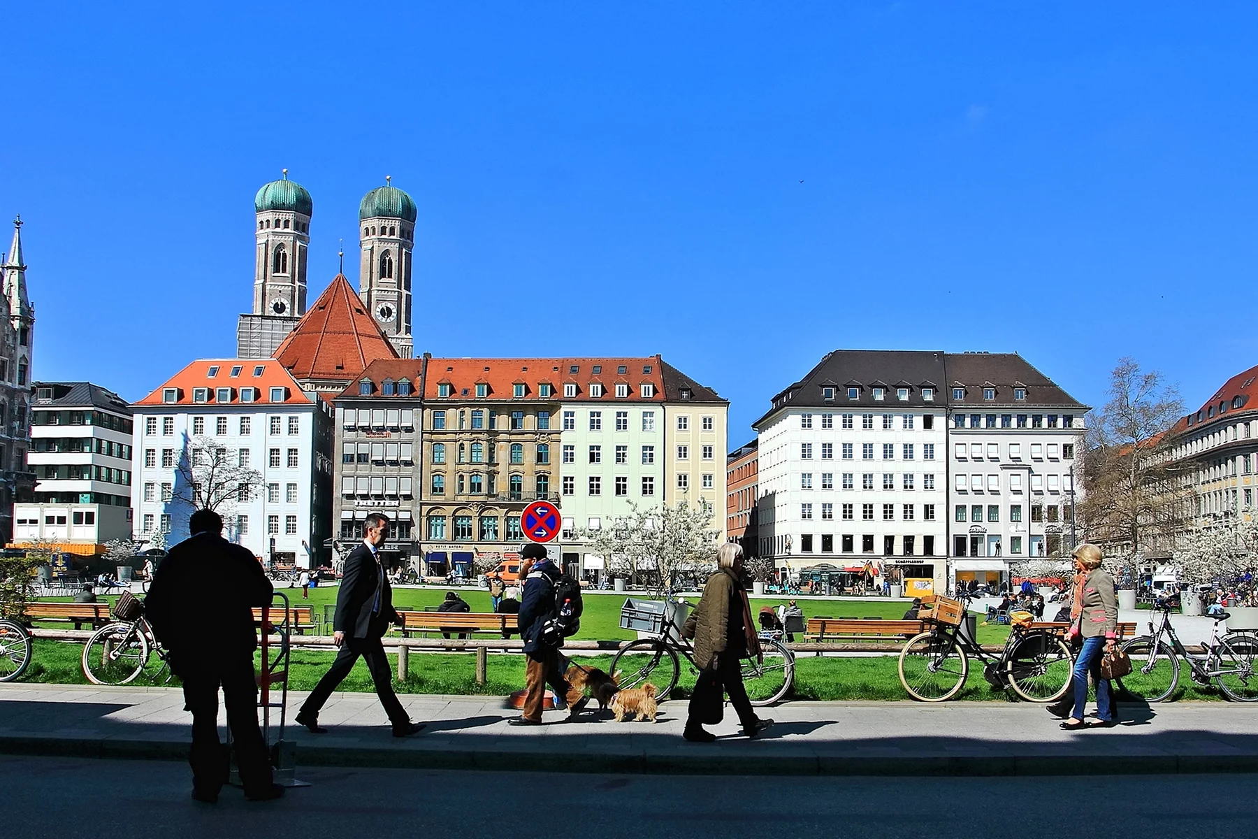 People walk past a park in Munich on a spring day