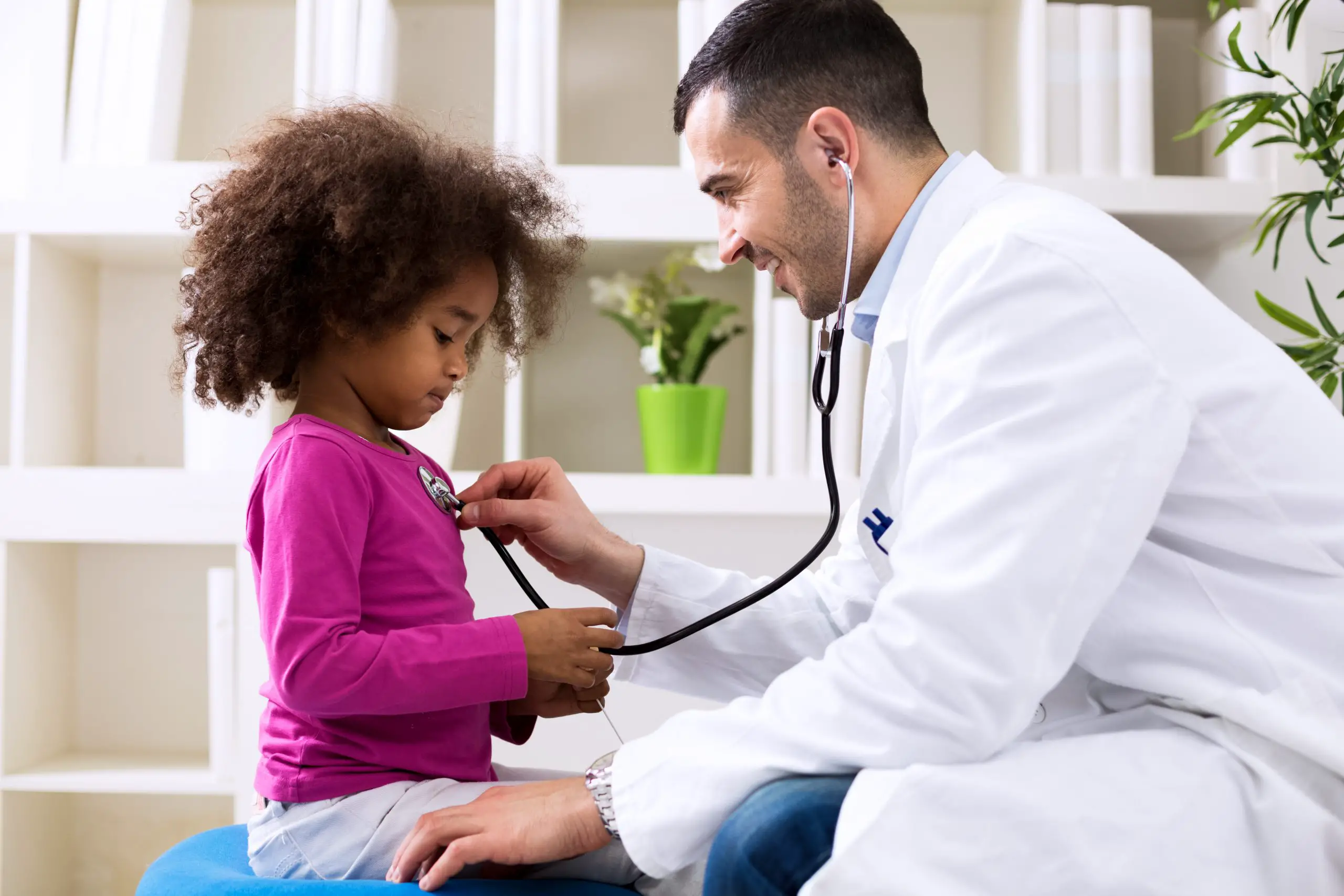 doctor uses stethoscope on young patient