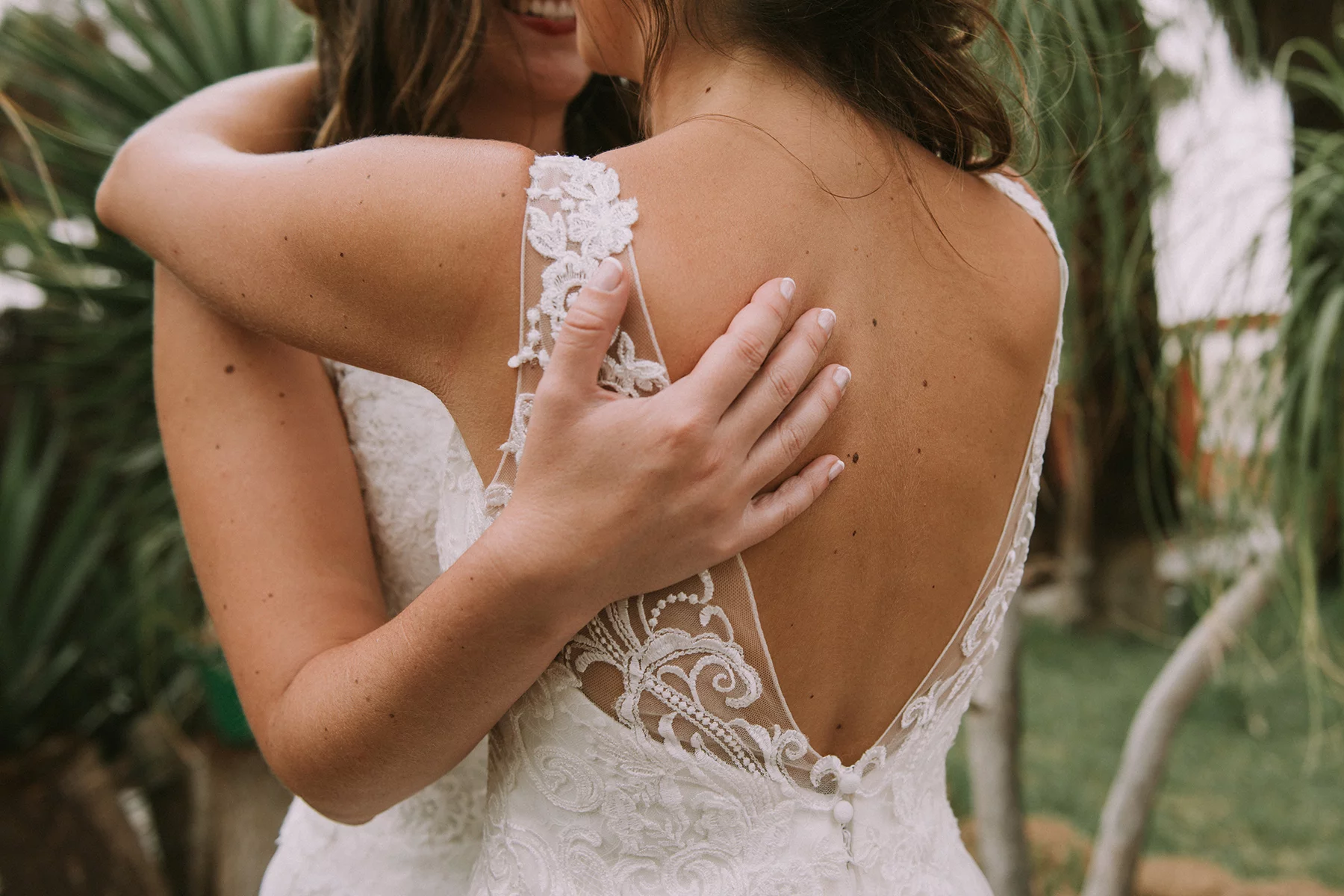 Two brides embracing at their wedding