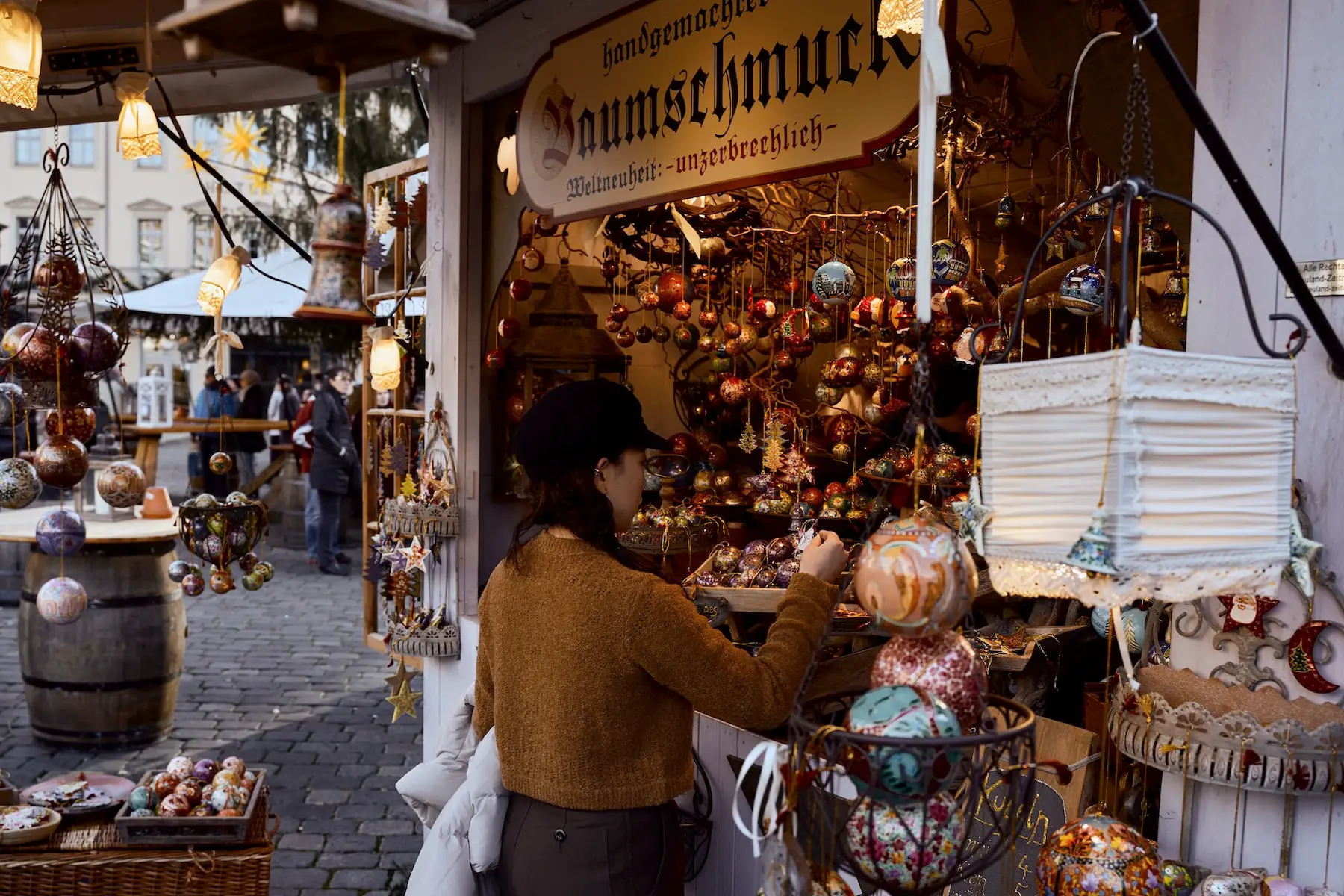 A woman shops for tree ornaments at a German Christmas market