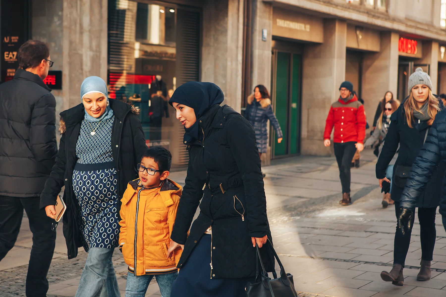 Two women and a child walking on a shopping street in Munich