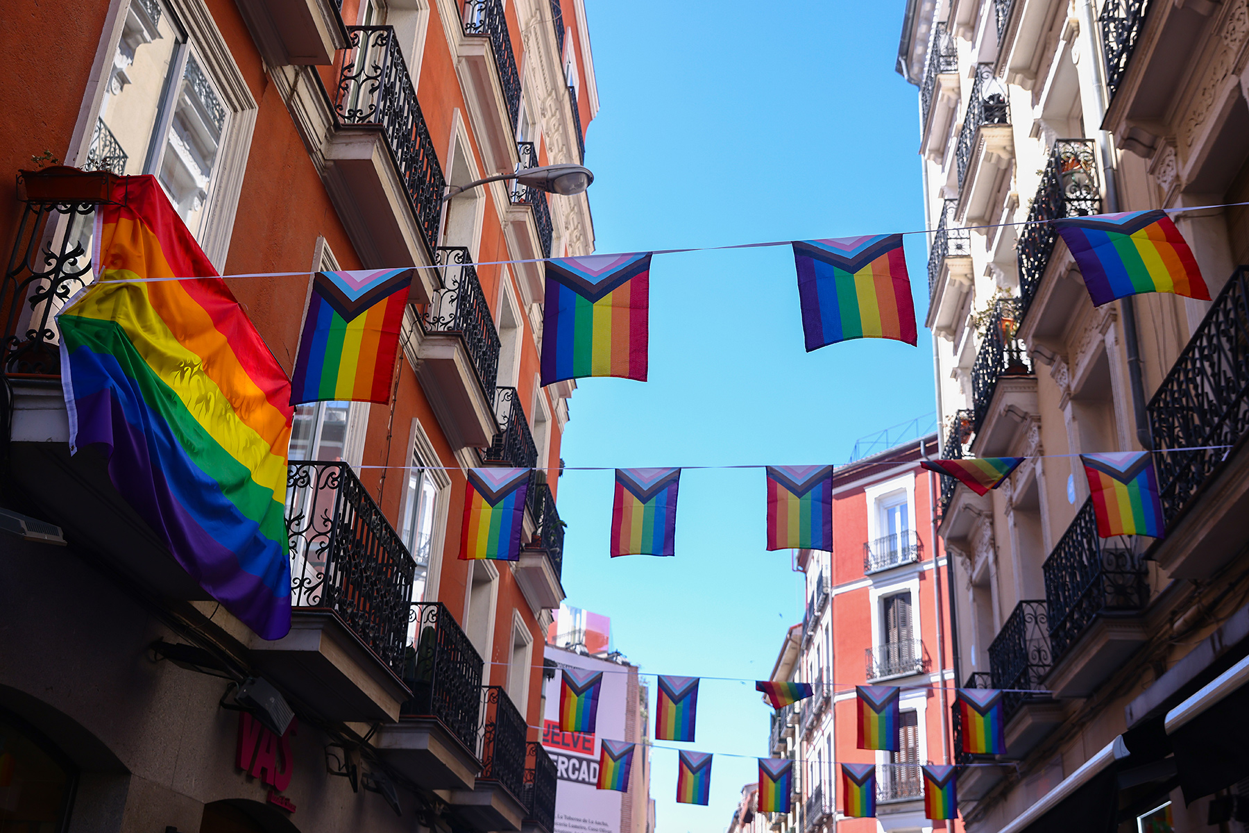 Pride flags hanging from buildings in Chueca, Madrid
