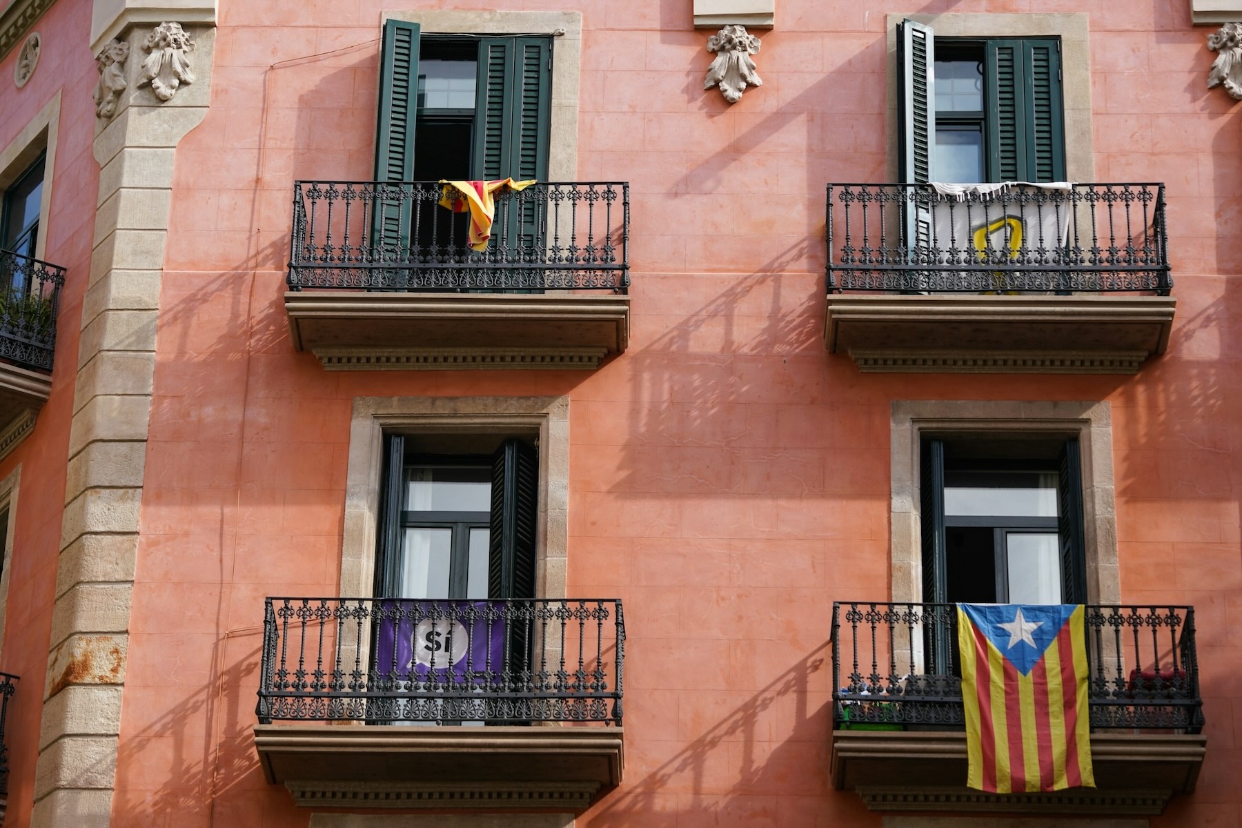 The exterior of a Spanish apartment building with balconies and open windows