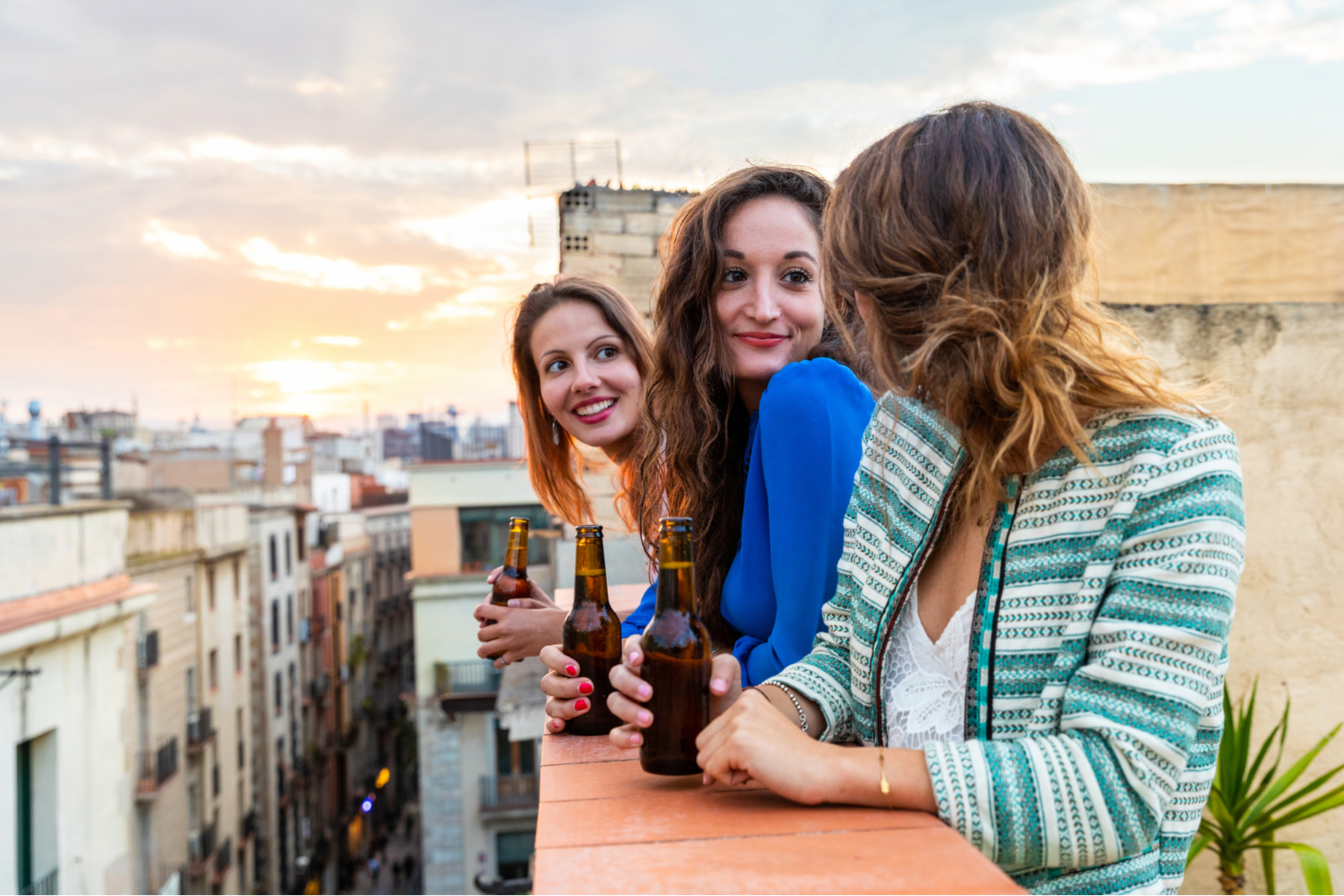 Friends drinking beer on a rooftop in the Gothic Quarter of Barcelona