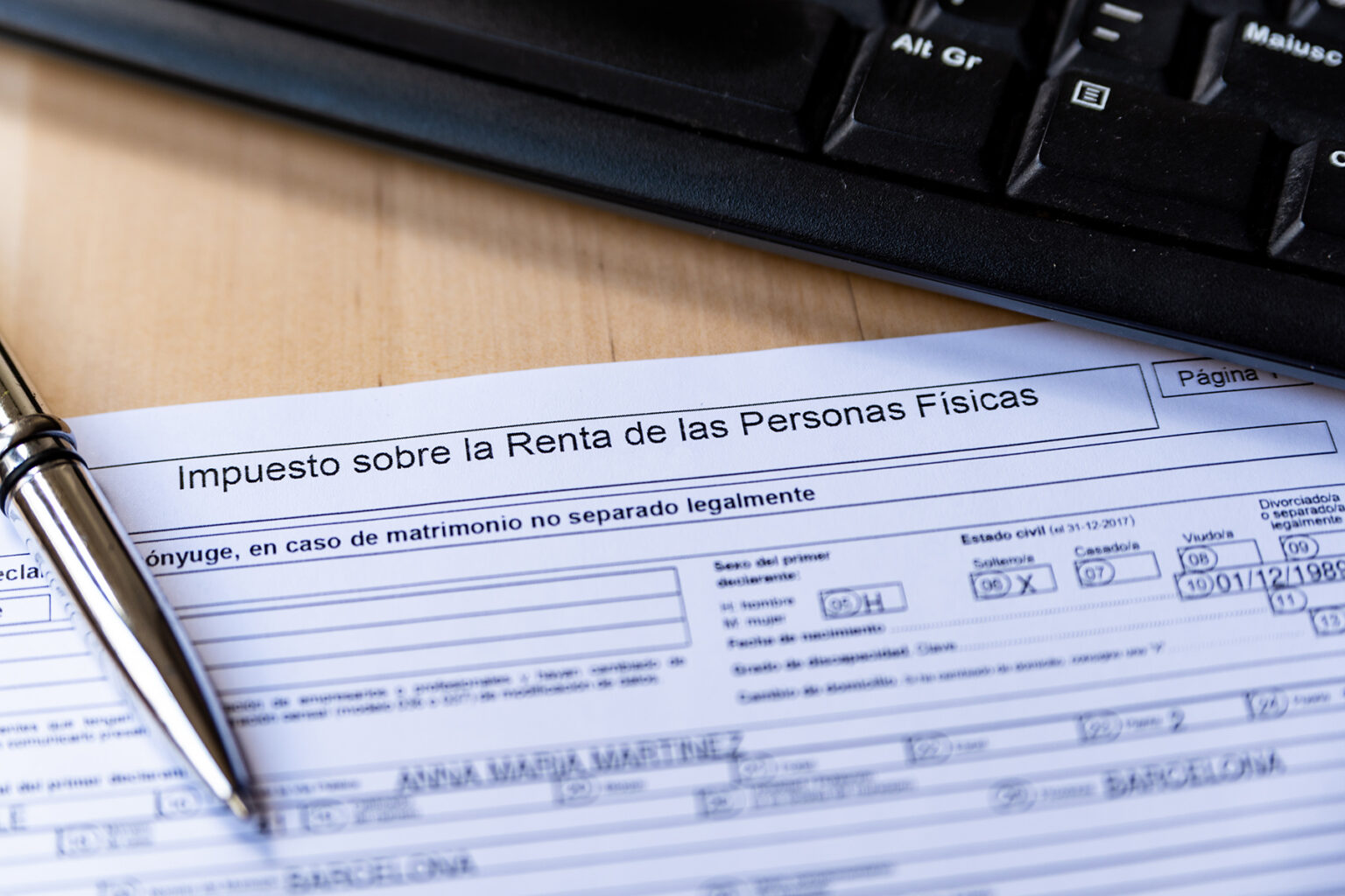 Close-up shot of a Spanish income tax return form with a pen