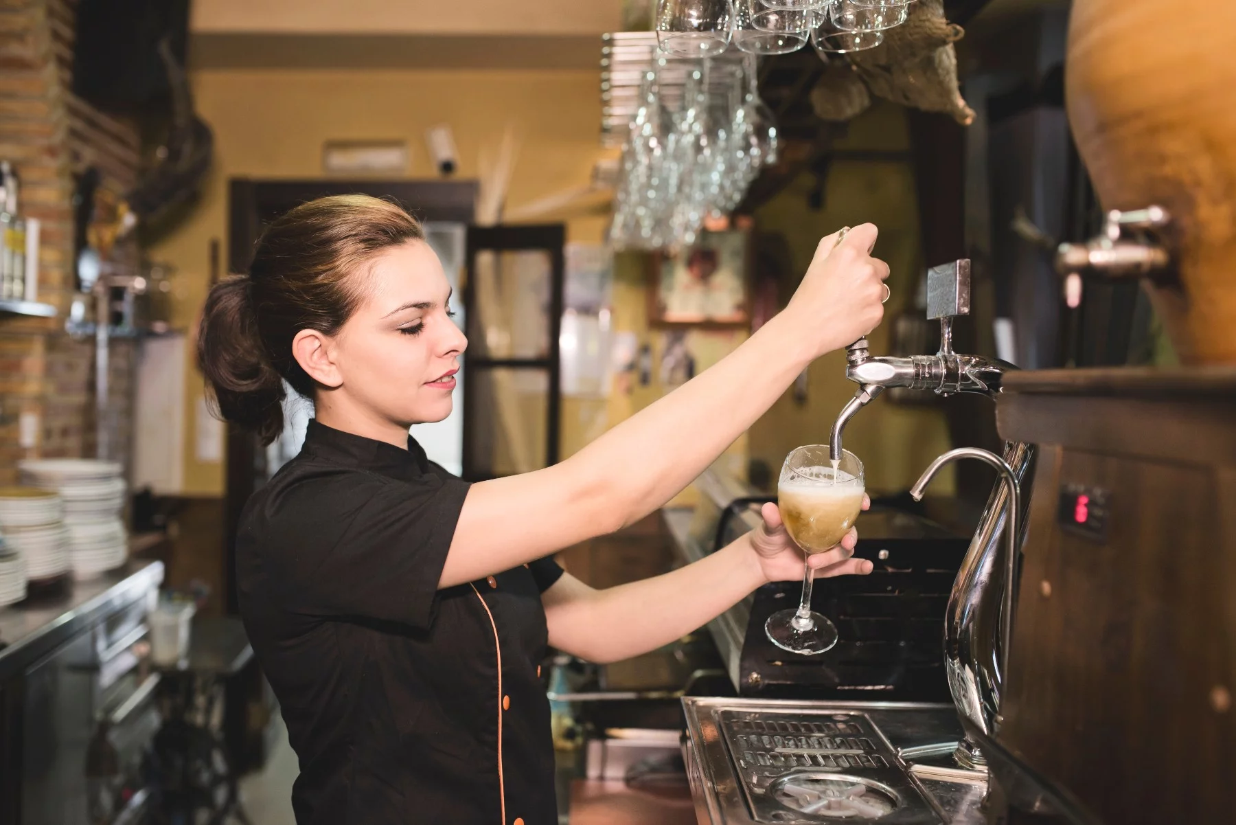 Service worker in Spain, bartender pours a beer