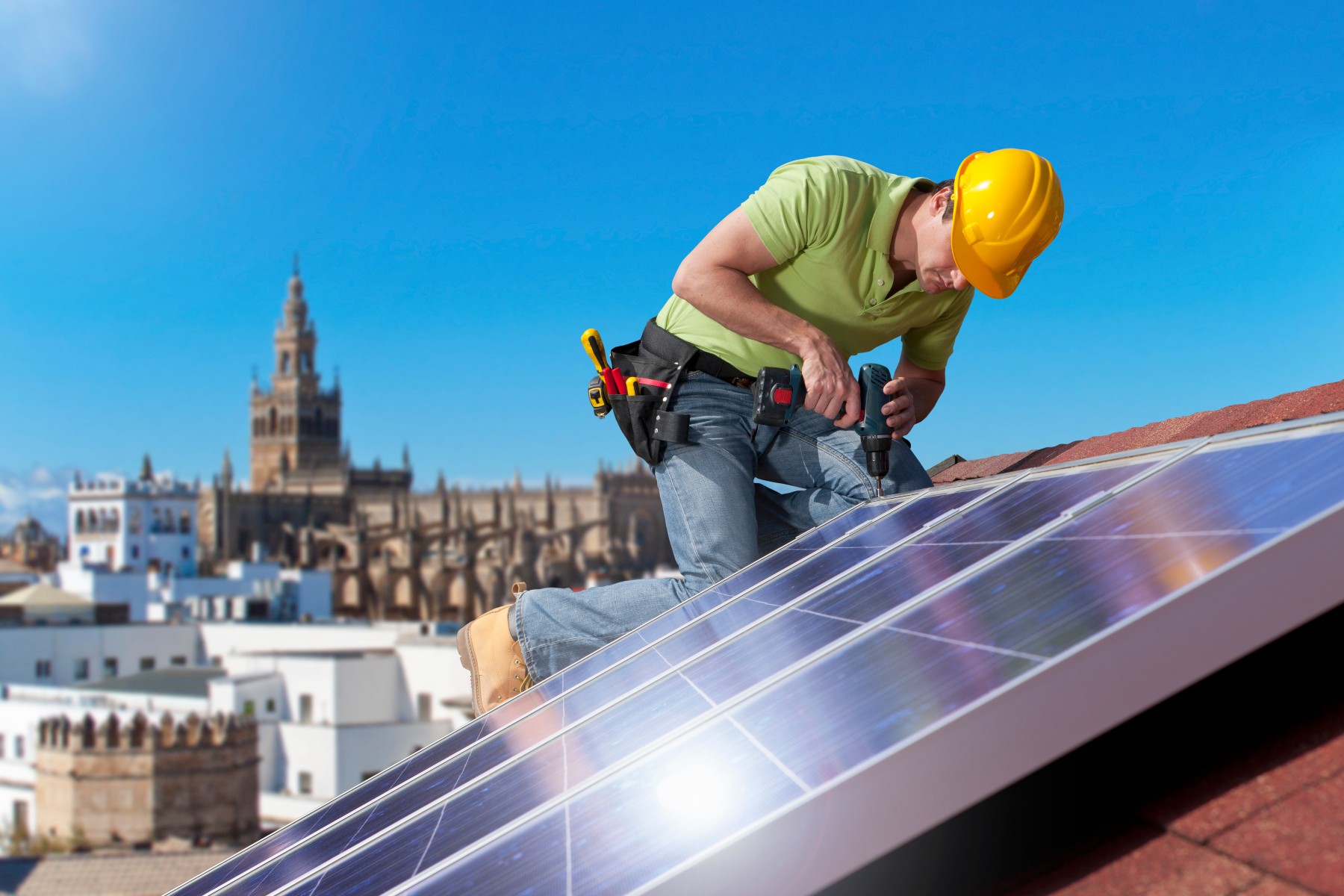 man installs solar panels on roof in Spain