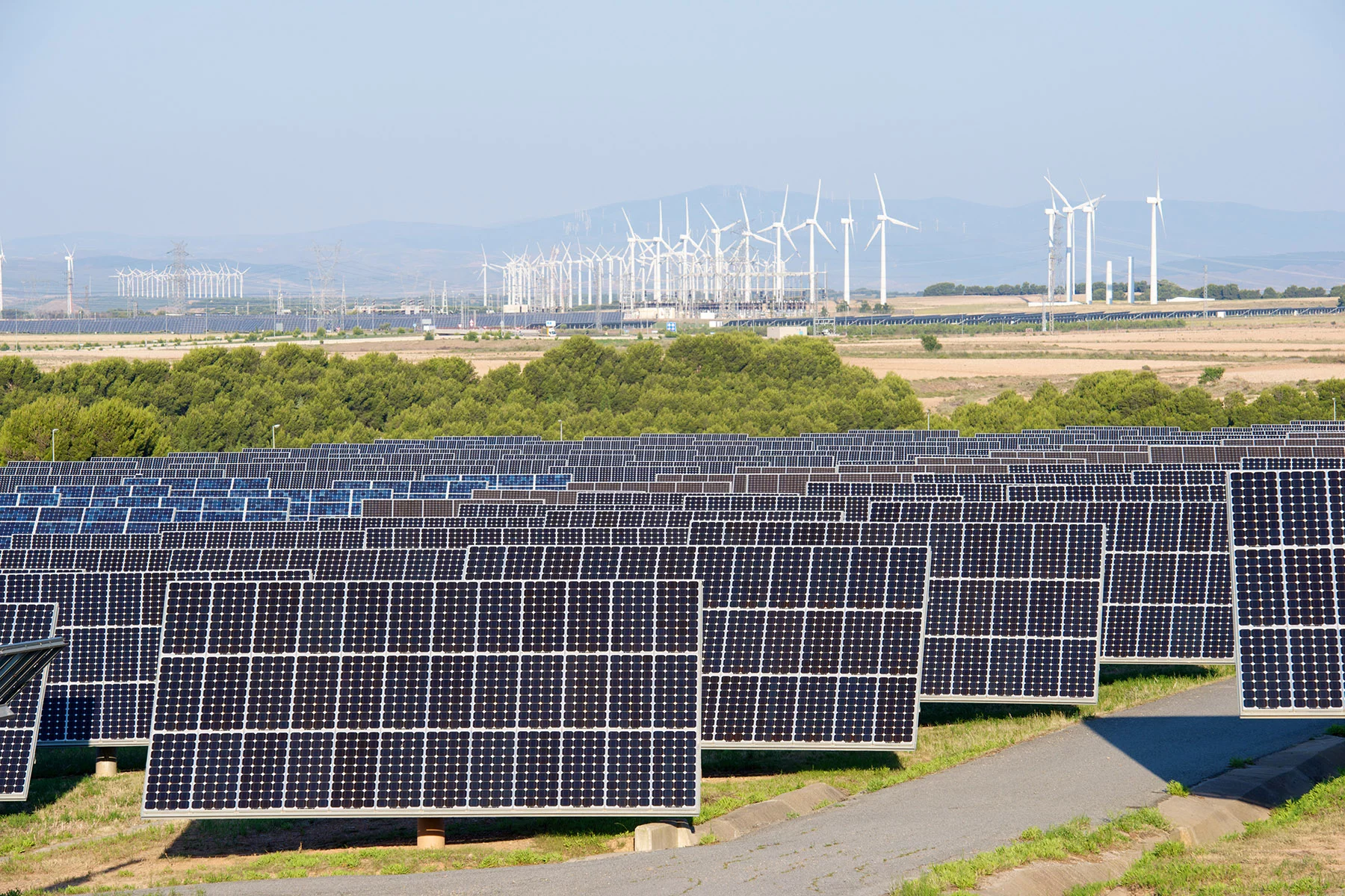 Solar panels in front of a wind power farm in Navarra, Spain